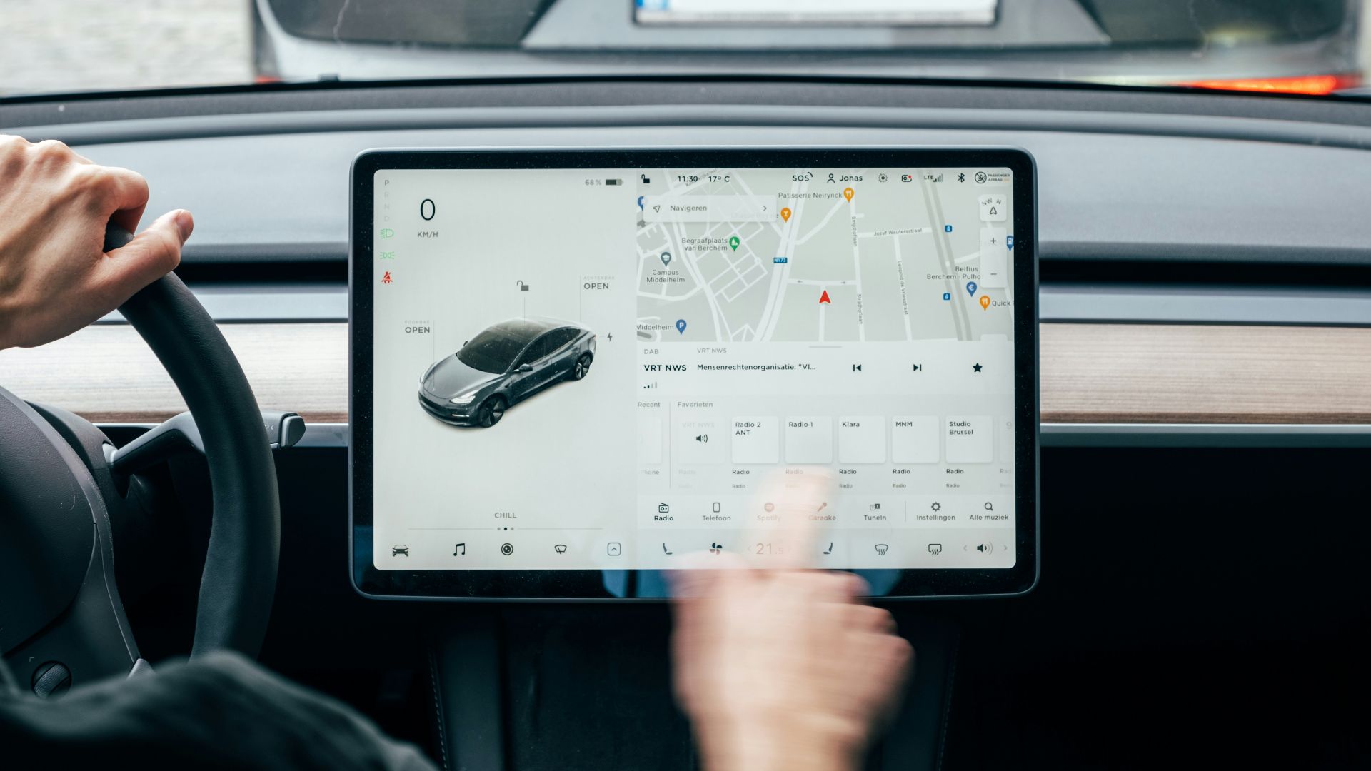 a person driving a car while holding a tablet