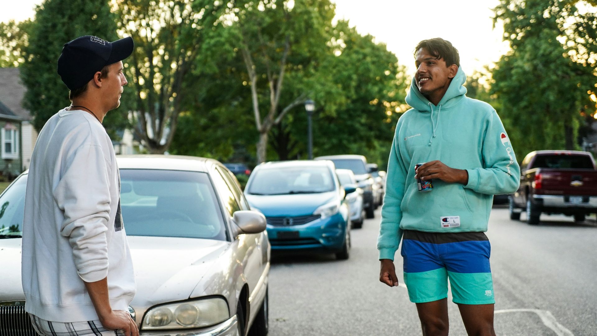 man in green hoodie standing on road during daytime