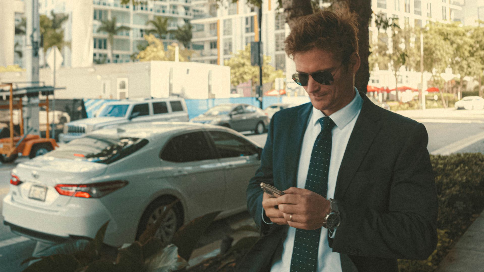 a man in a suit and tie looking at his cell phone
