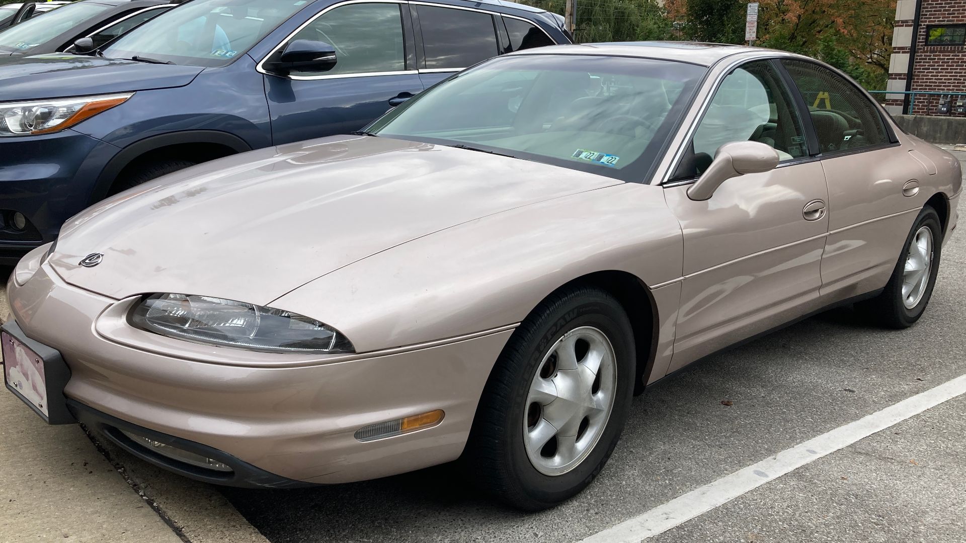 A 1998 Oldsmobile Aurora base model in Champagne Metallic. This Aurora is equipped with the 4.0L V8 engine, and assembled in Orion, Michigan. This Aurora is in perfect condition, even 24 years later. These were actually good cars, but still didn't save Ol