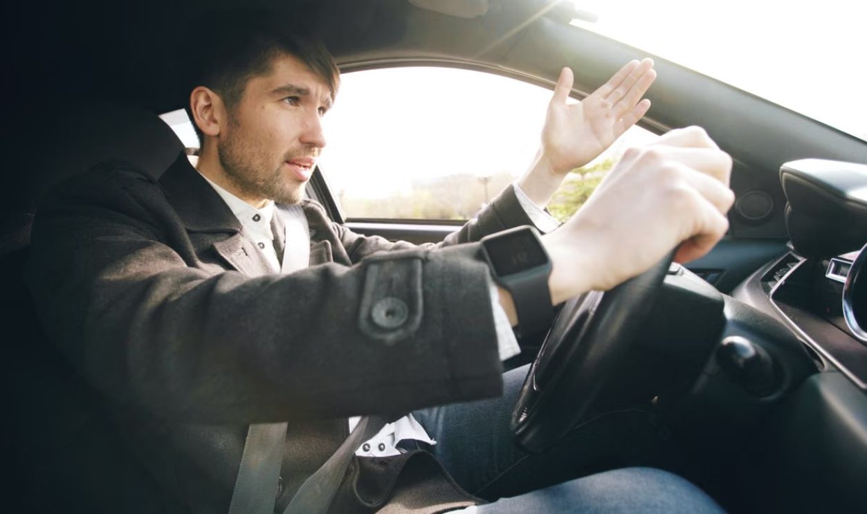 Man showing frustration while driving a car, highlighting road rage issues