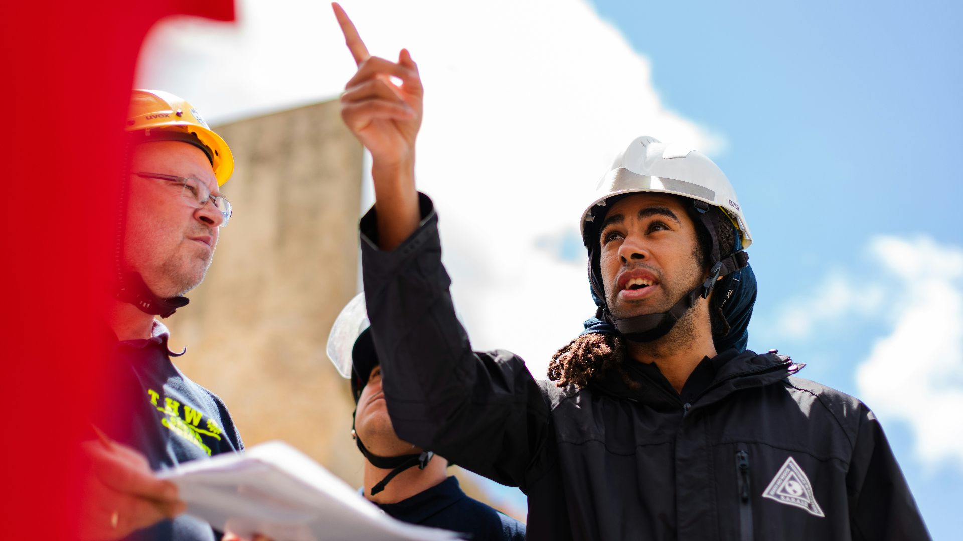 man in black jacket wearing yellow hard hat
