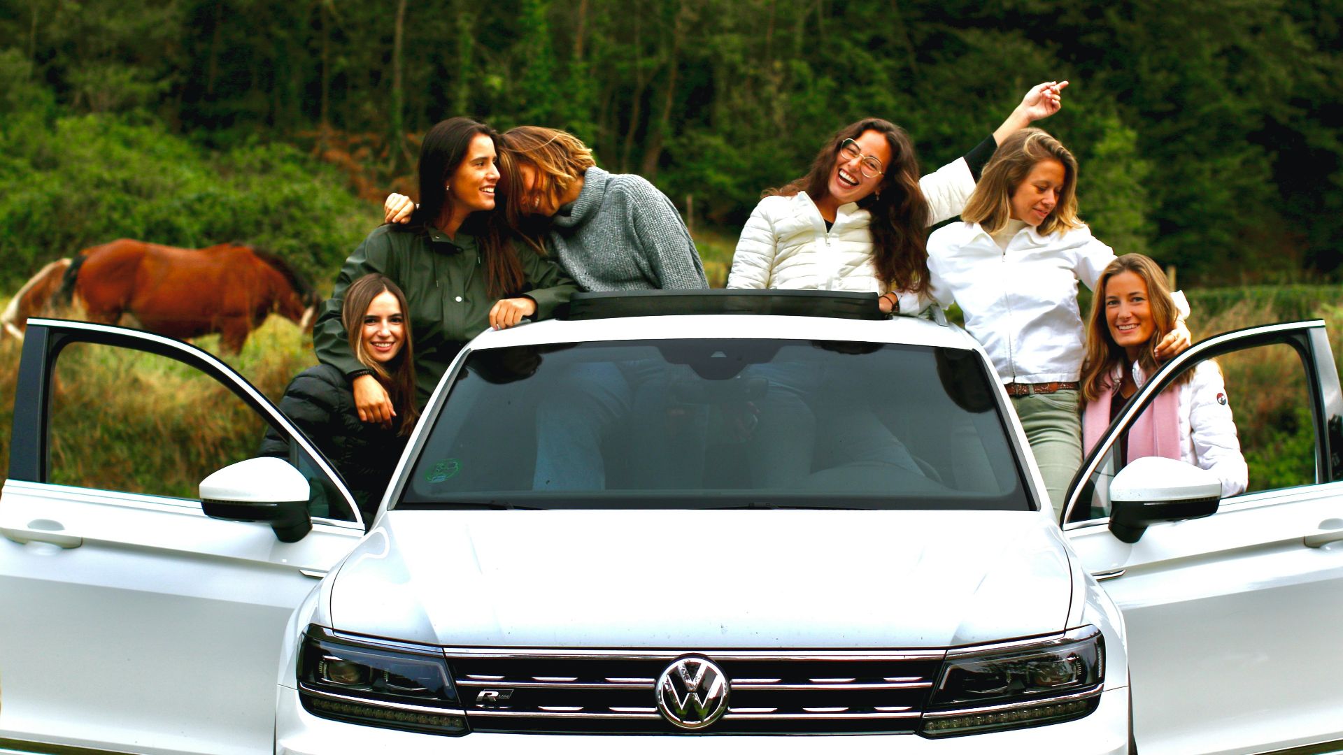 group of people standing beside white car during daytime