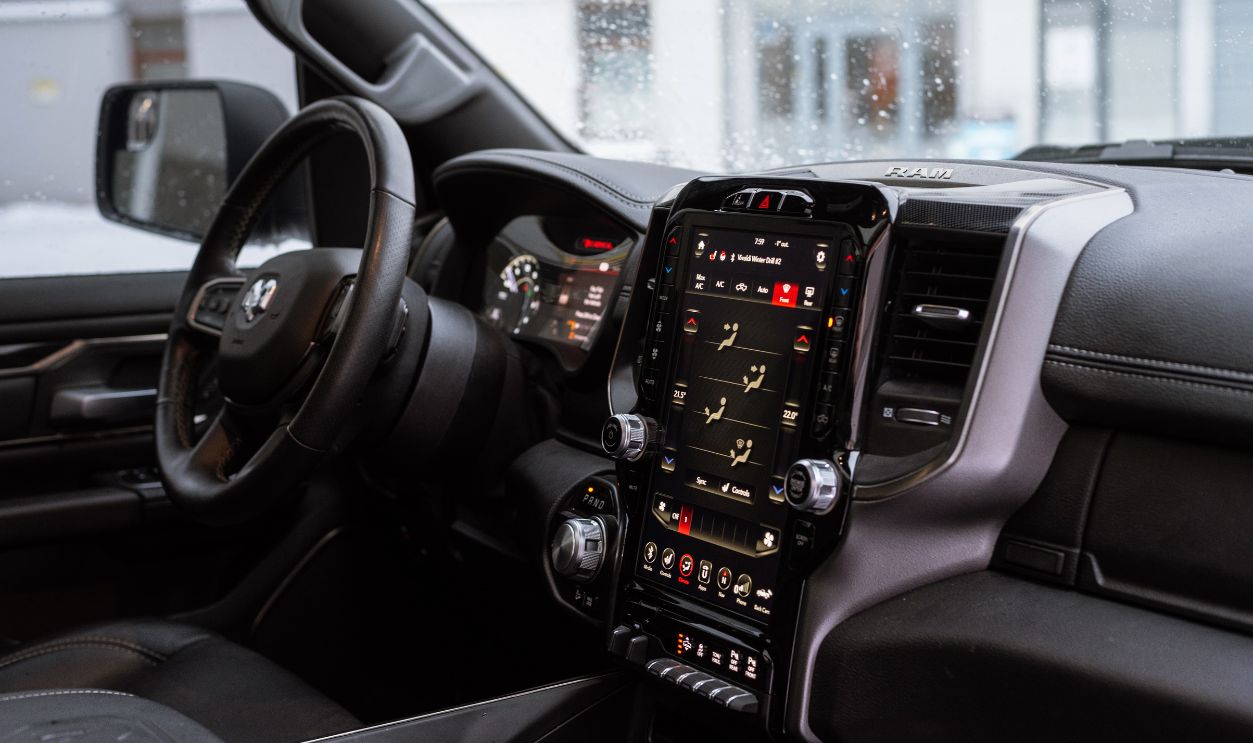Interior view of a modern vehicle featuring a digital touchscreen dashboard and steering wheel