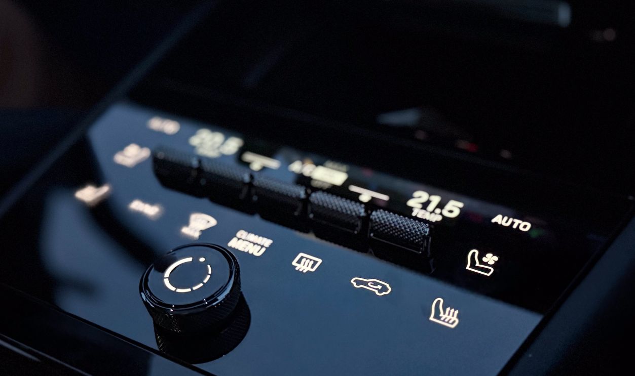 Close up of a car climate control panel with digital display, touch buttons, and a knob inside a modern vehicle interior porsche macan 4 electric Poland, Pszczyna, 3.08.2026