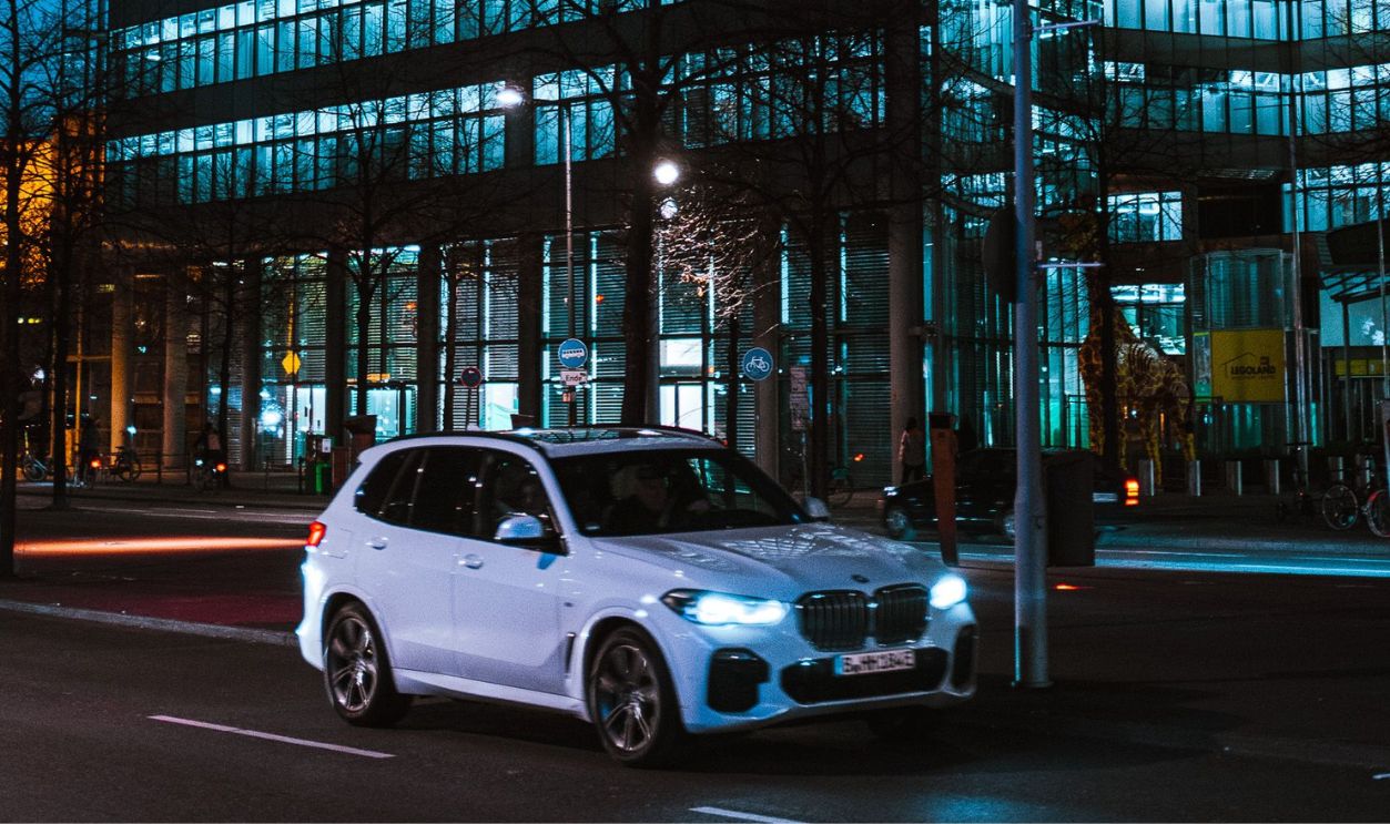 Illuminated office building with a car passing by at night in Berlin, Germany