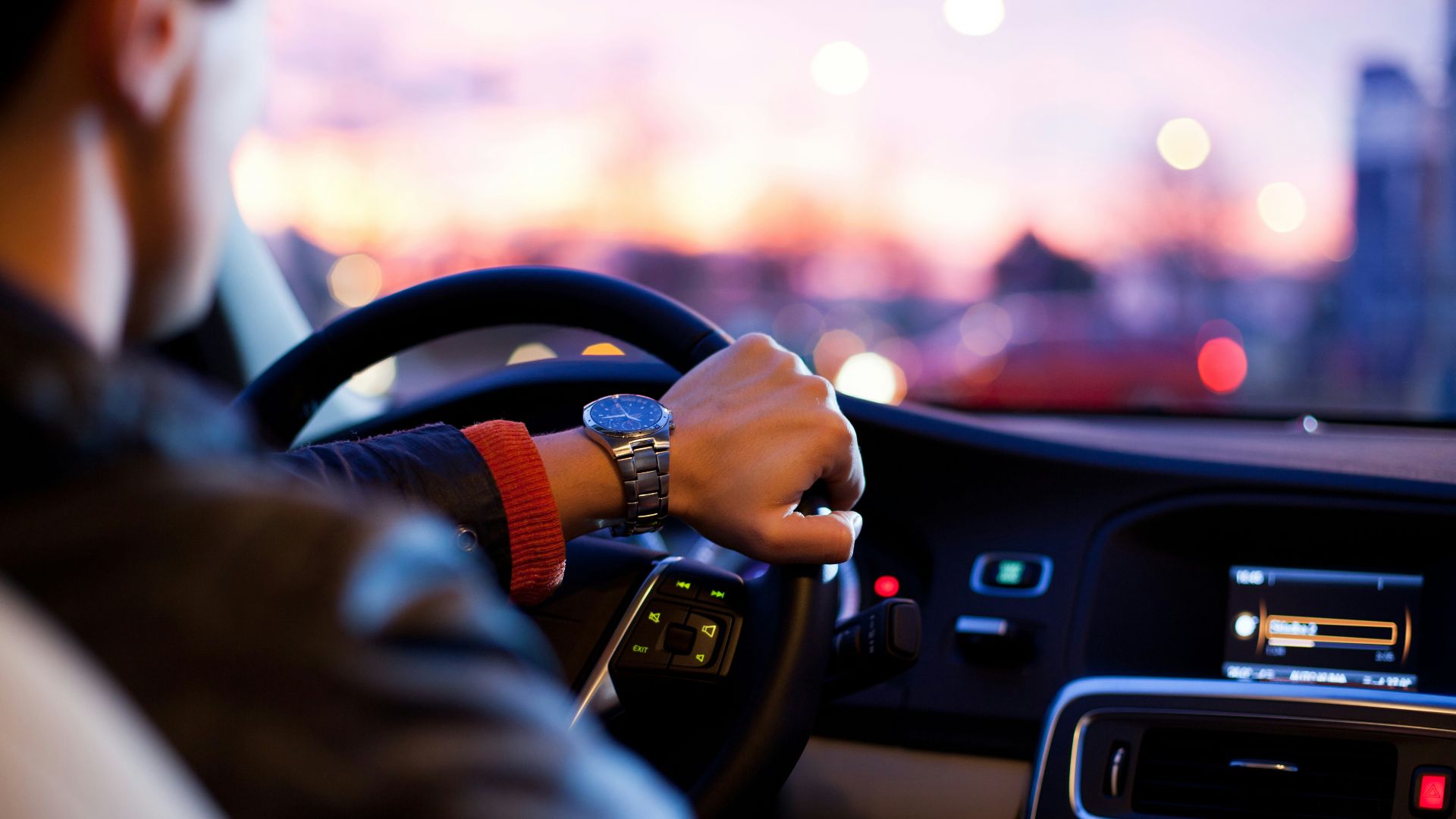 man driving a car wearing wrist watch
