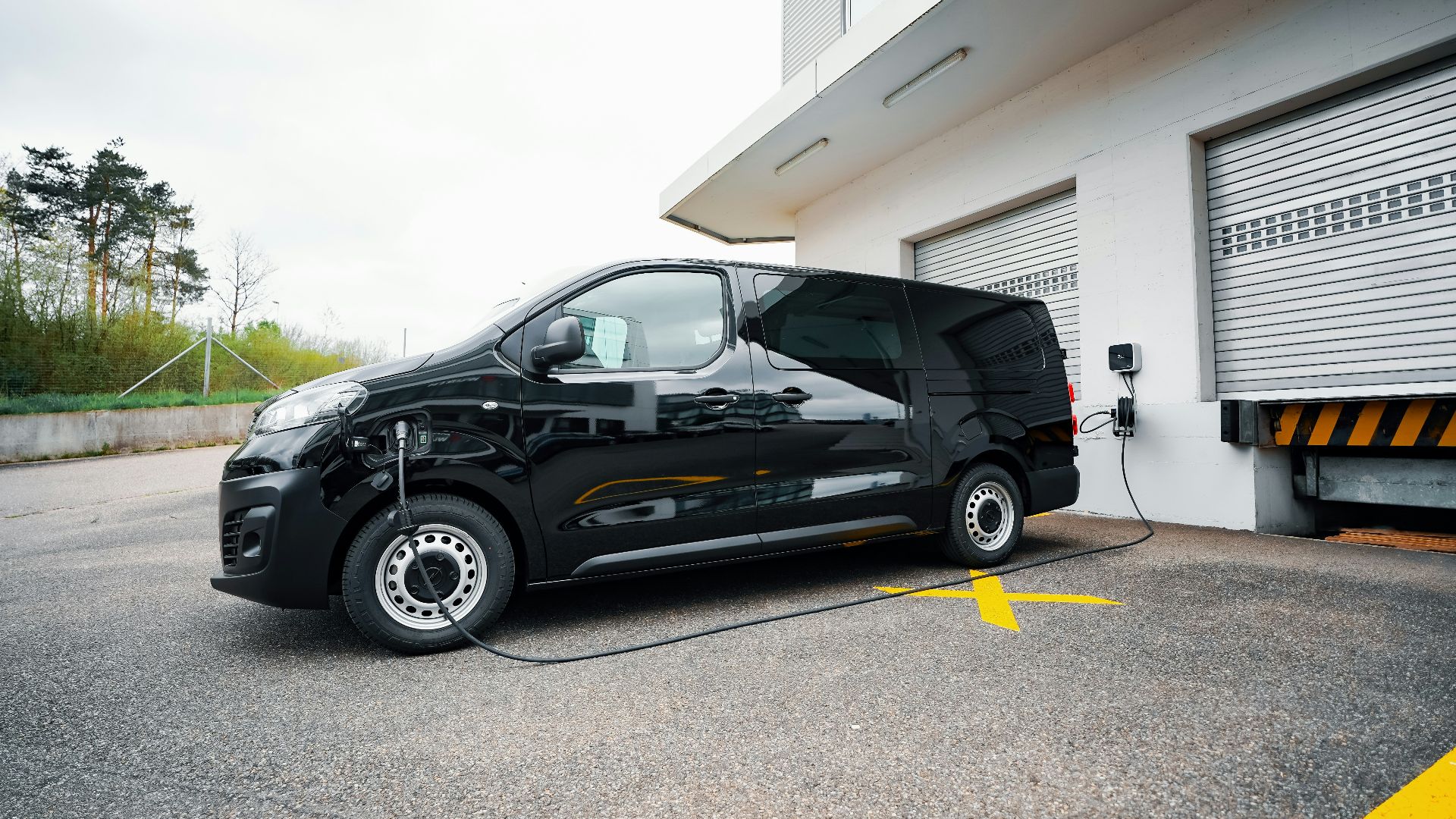 A small black car parked in front of a garage