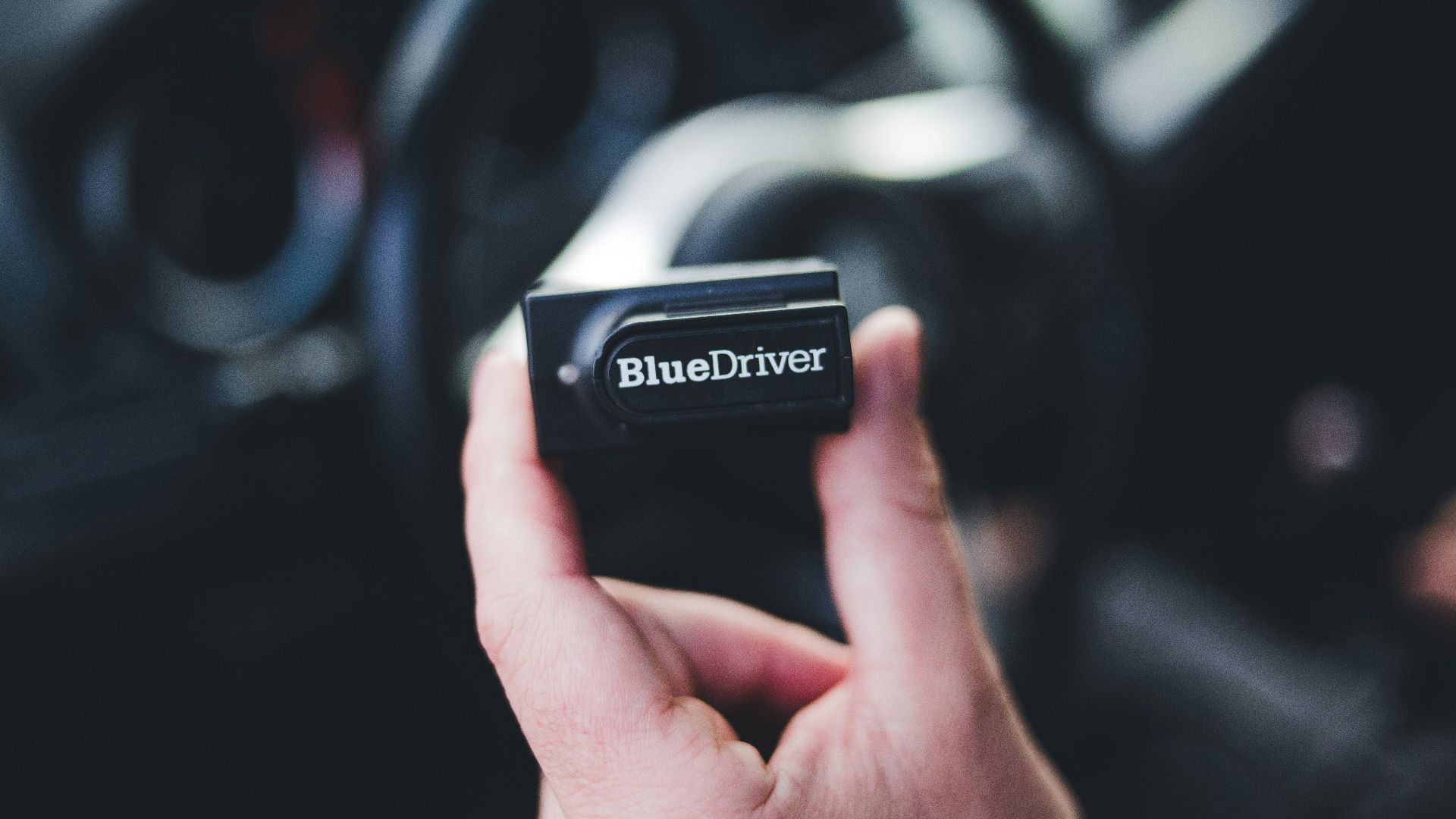 a hand holding a black device