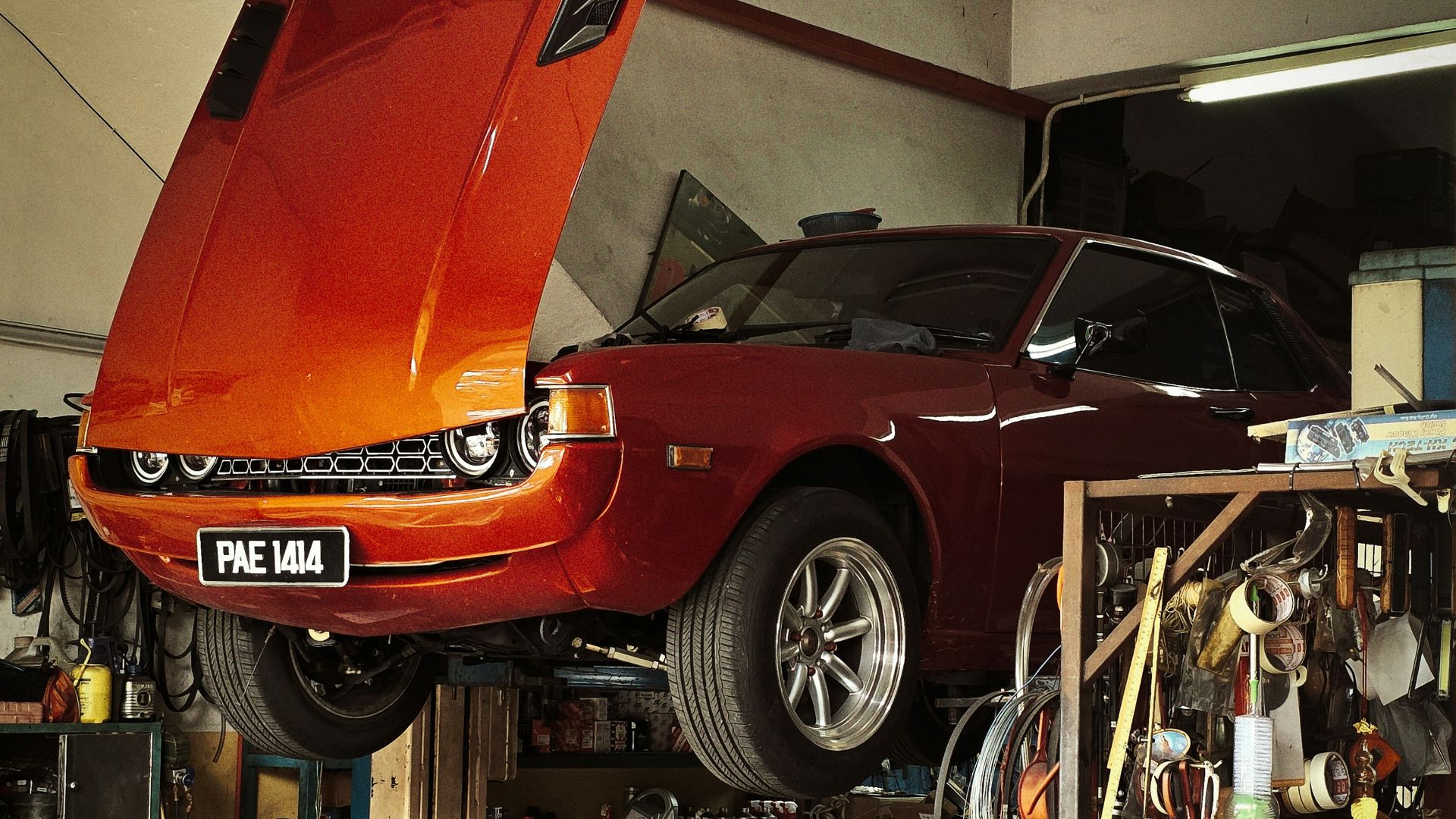 Orange classic car being repaired in garage