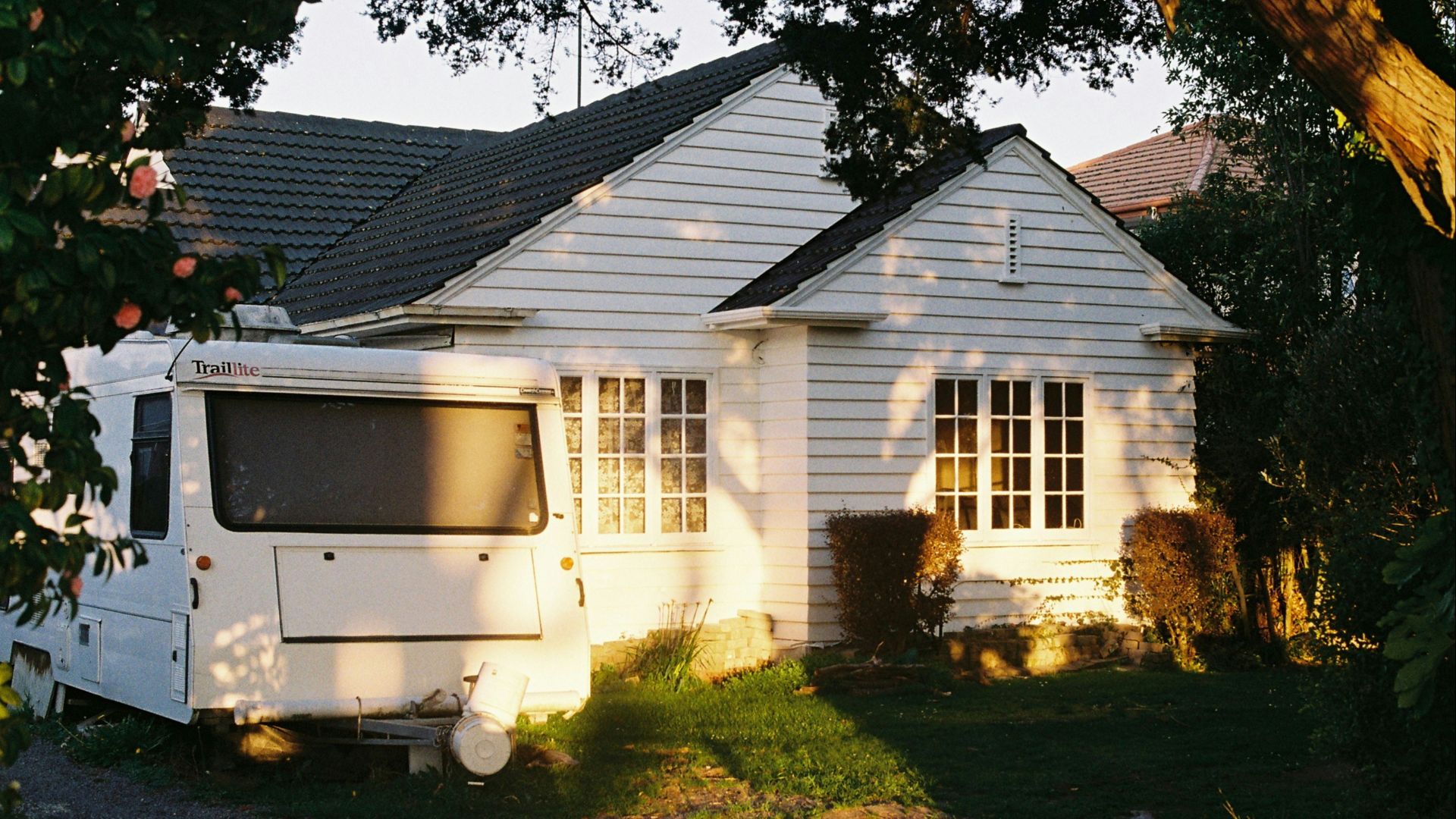 A white house with a white trailer parked in front of it