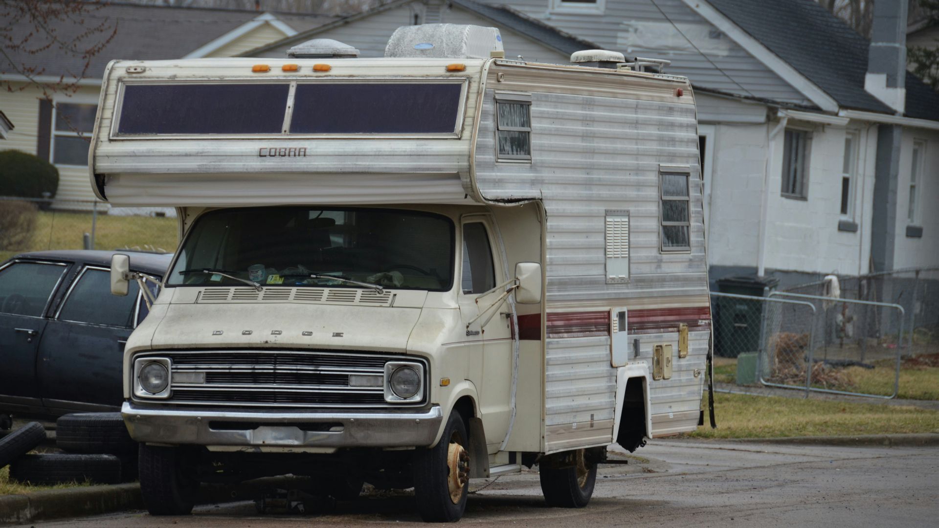 an rv parked in a driveway next to a house