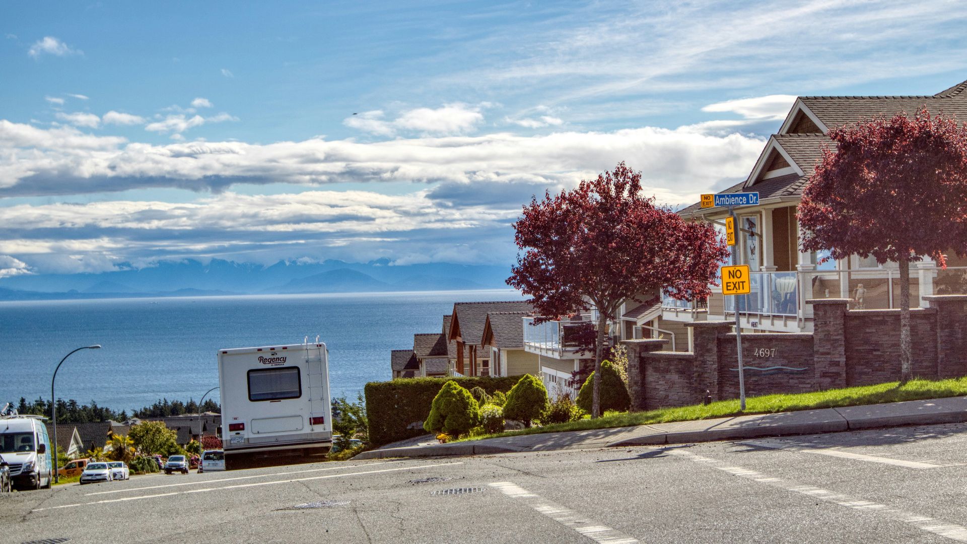 a view of a street with a car parked on the side of the road