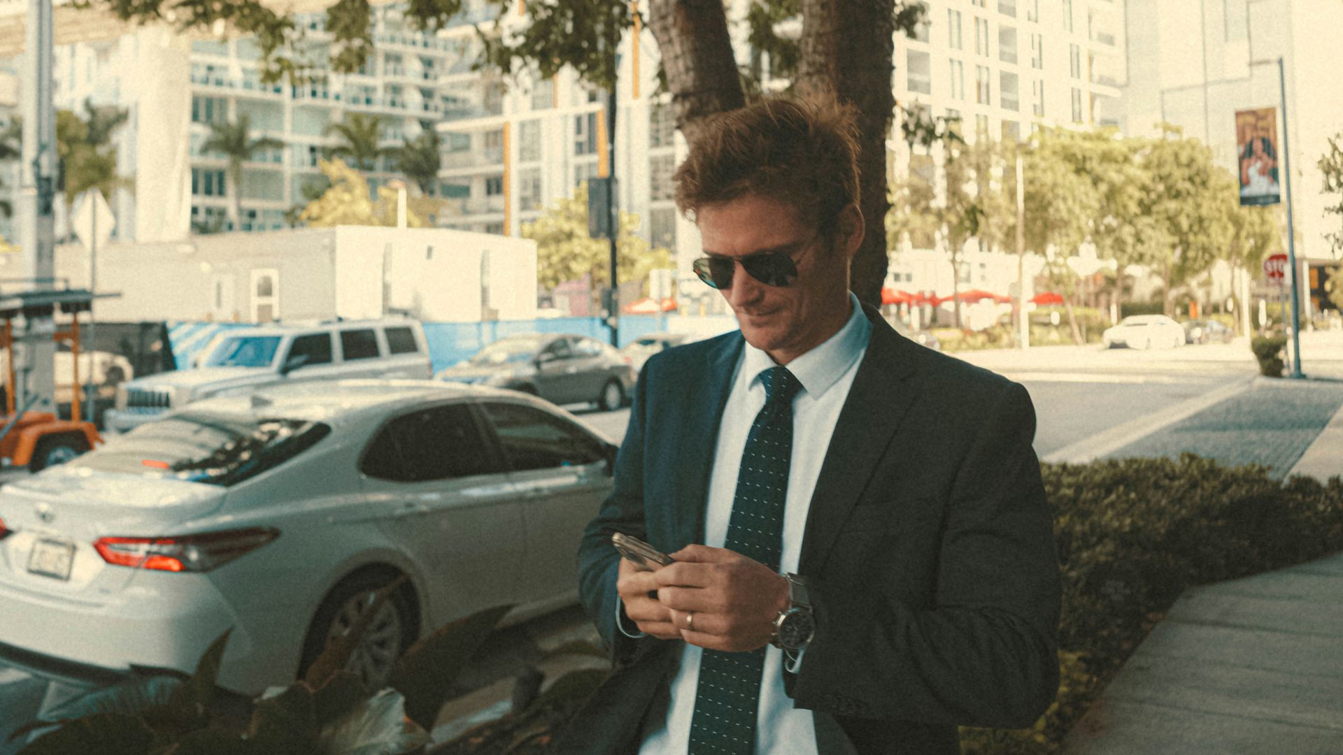 a man in a suit and tie looking at his cell phone