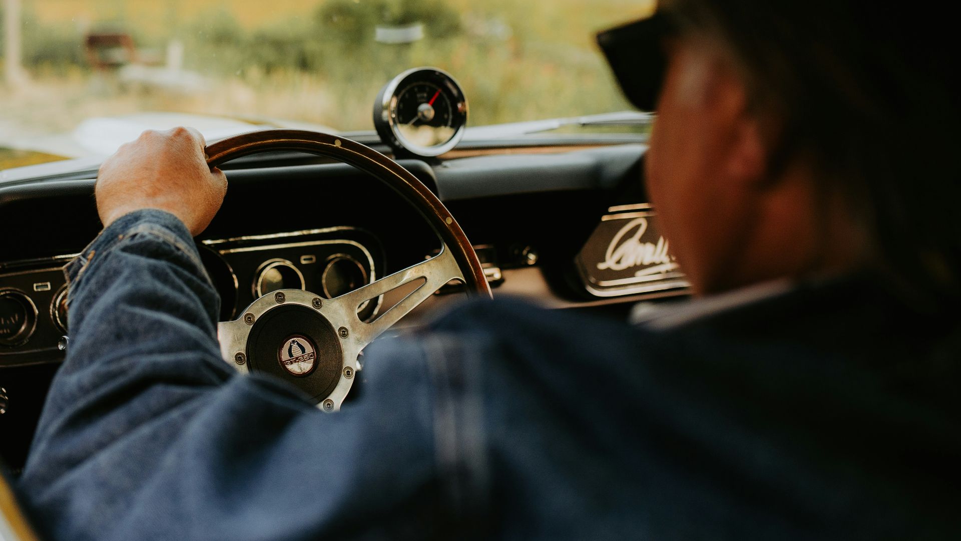 a man driving a car down a country road