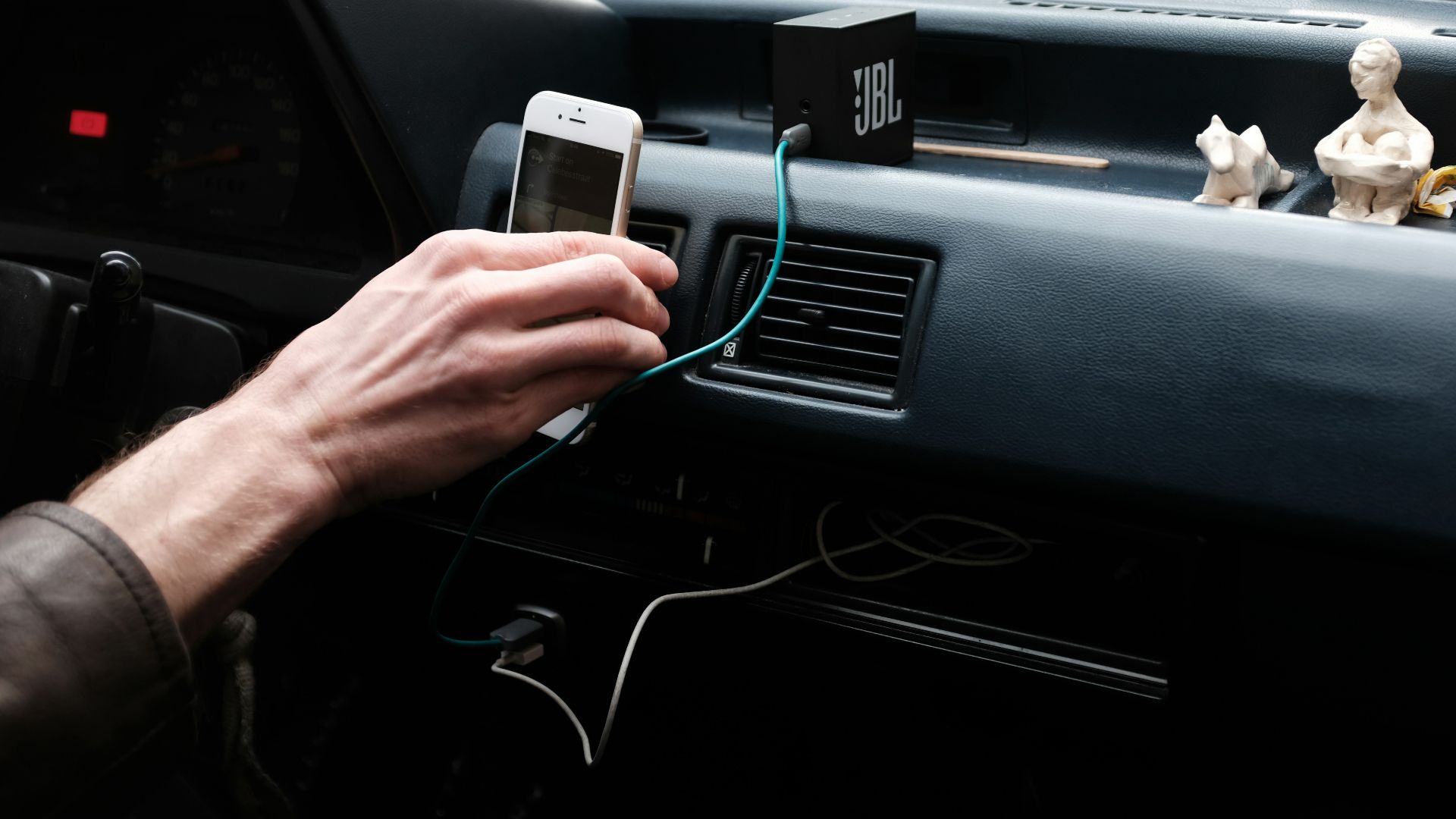 person hand holding iPhone 6 on dashboard during daytime