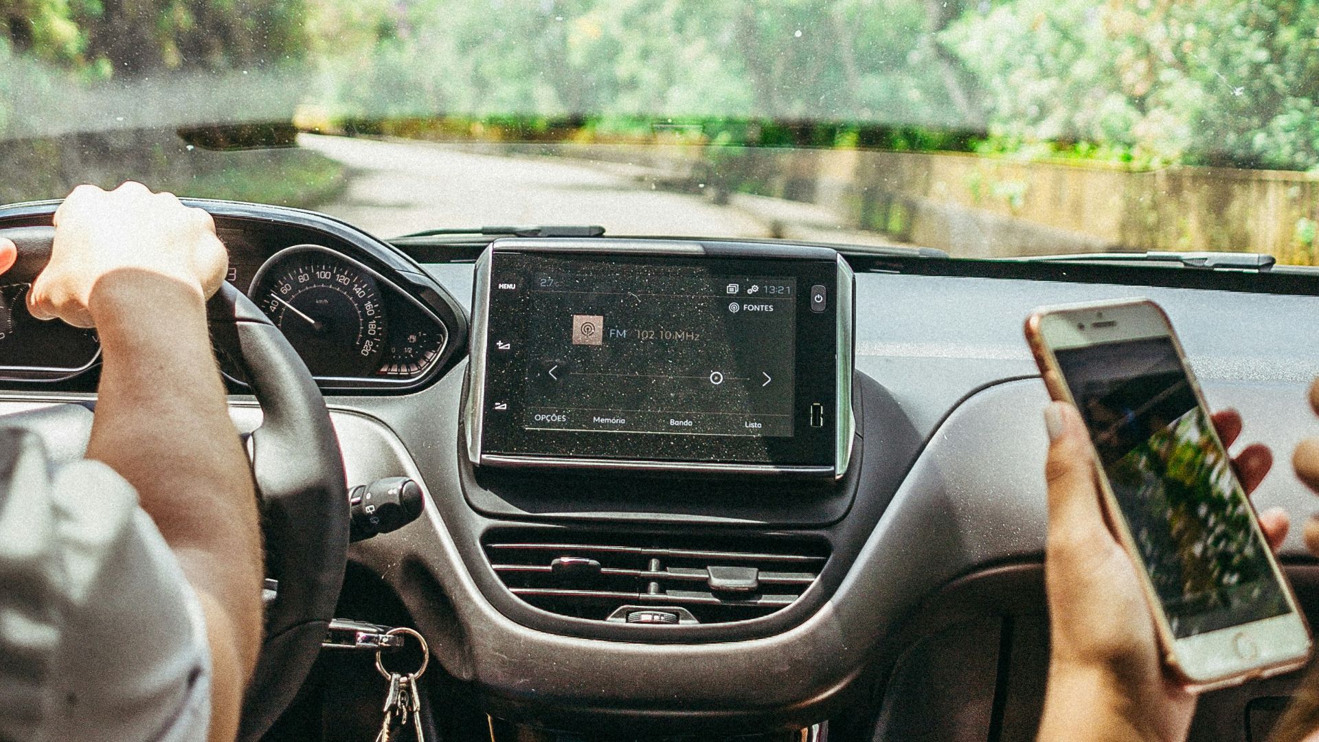 man at the car seat holding his phone beside the driver