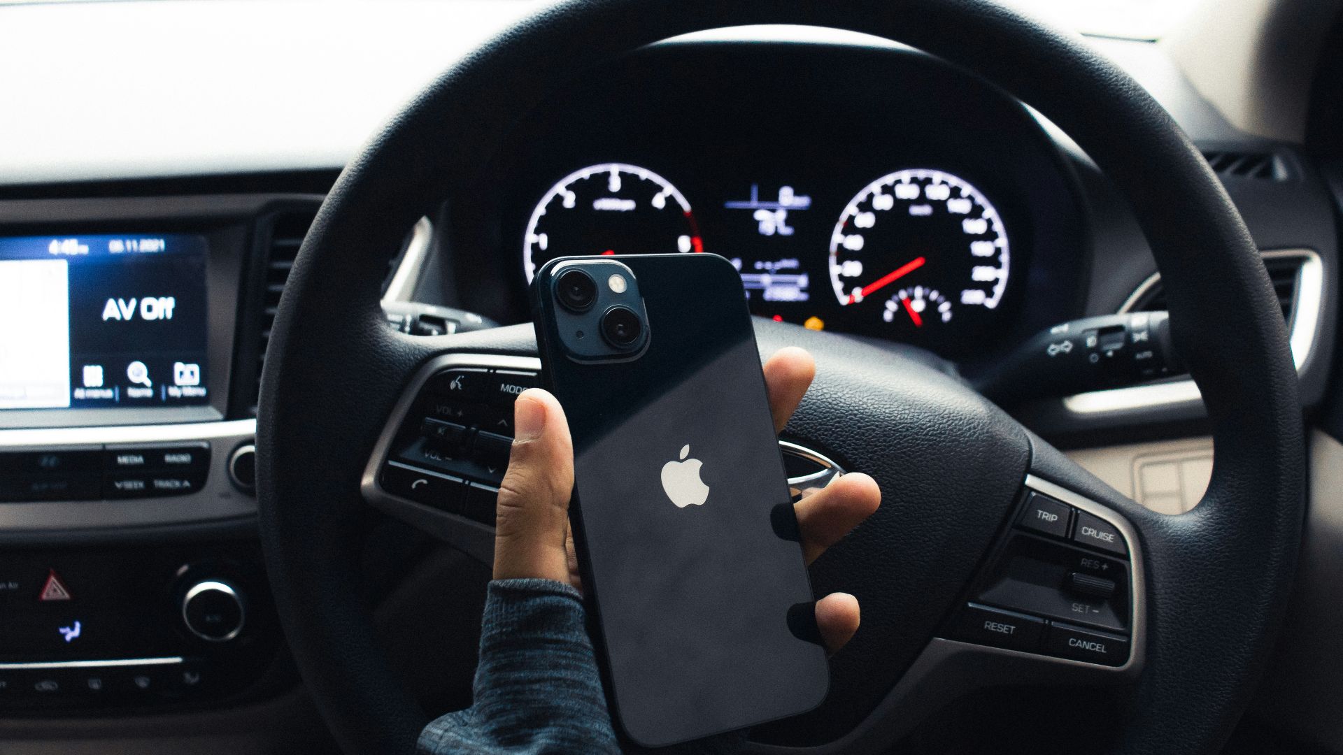 a person holding a cell phone in a car