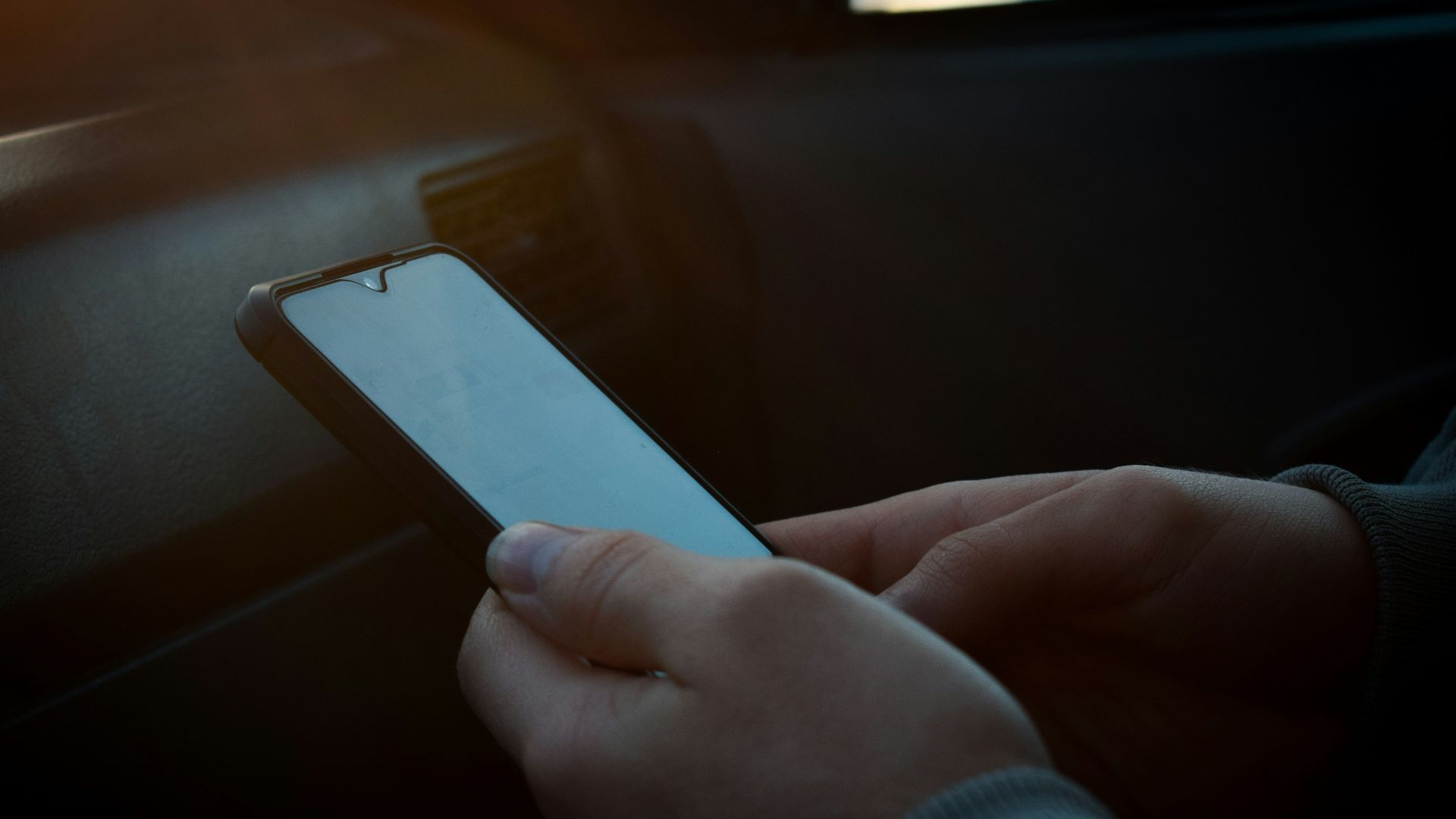 a person holding a cell phone in their hand