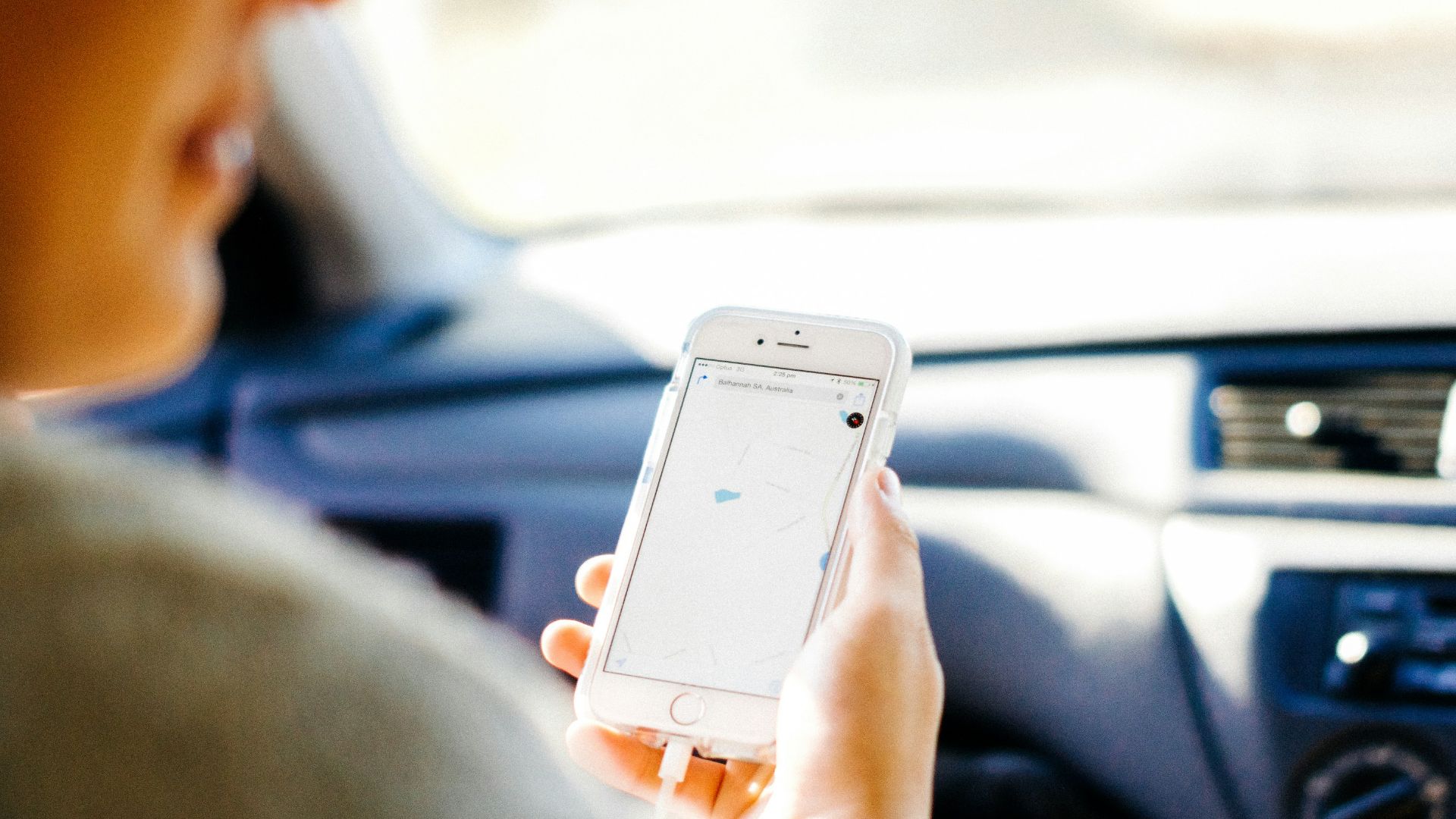 a woman holding a cell phone in a car