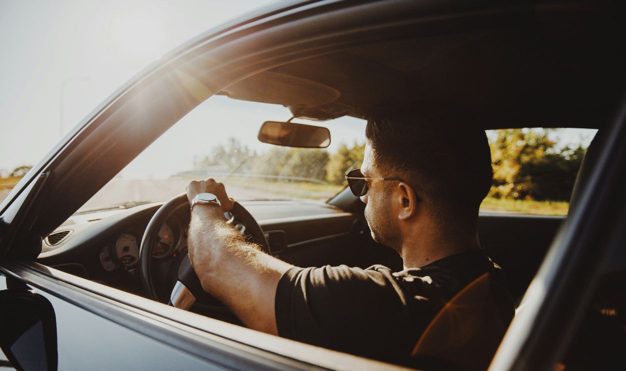 Man in black jacket driving car