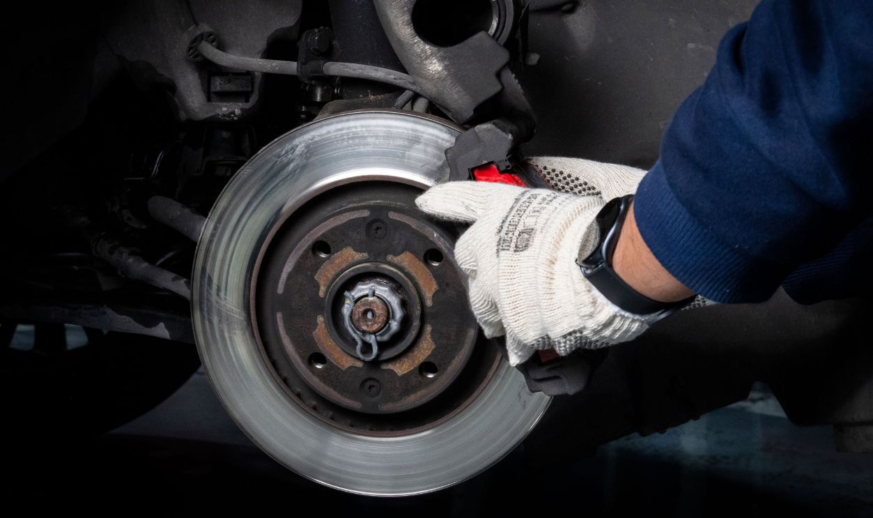 Mechanic working on car brake system in a workshop