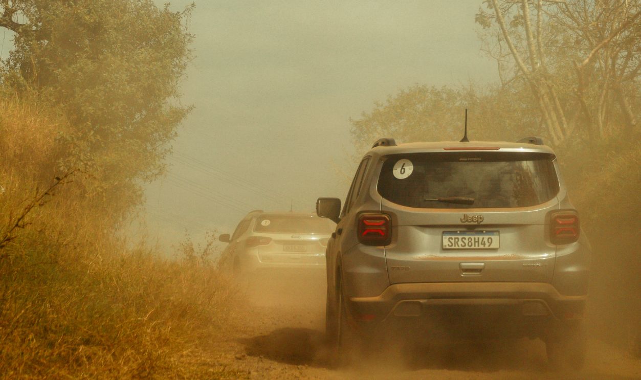 Two SUVs navigate a dusty off-road trail, creating a thrilling adventure scene.