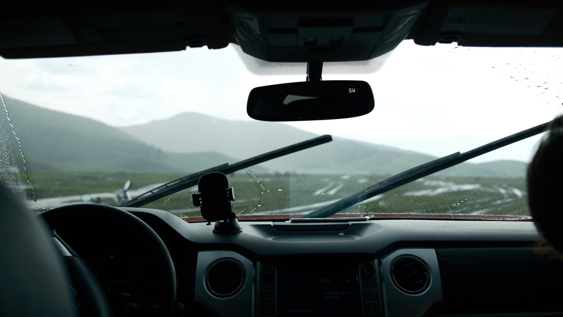 Driving through mountains with rain on windshield