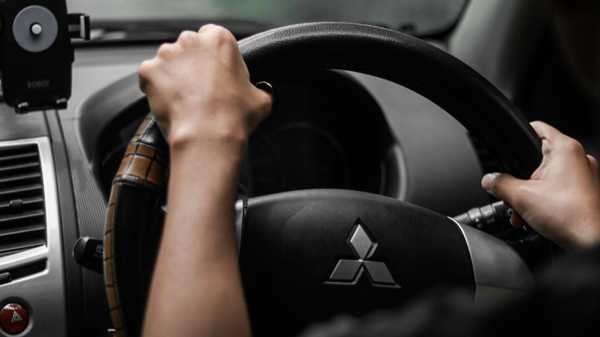 a person driving a car with a steering wheel