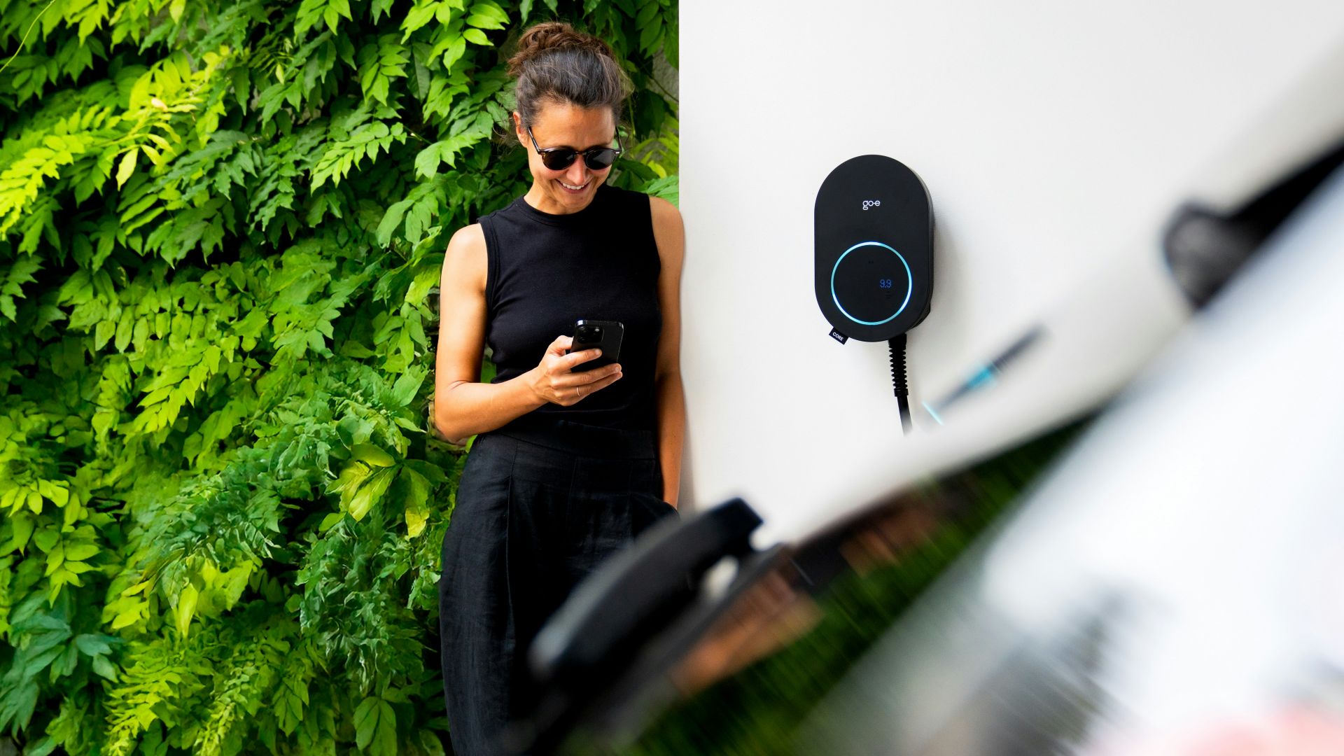 Woman using phone near electric car charger