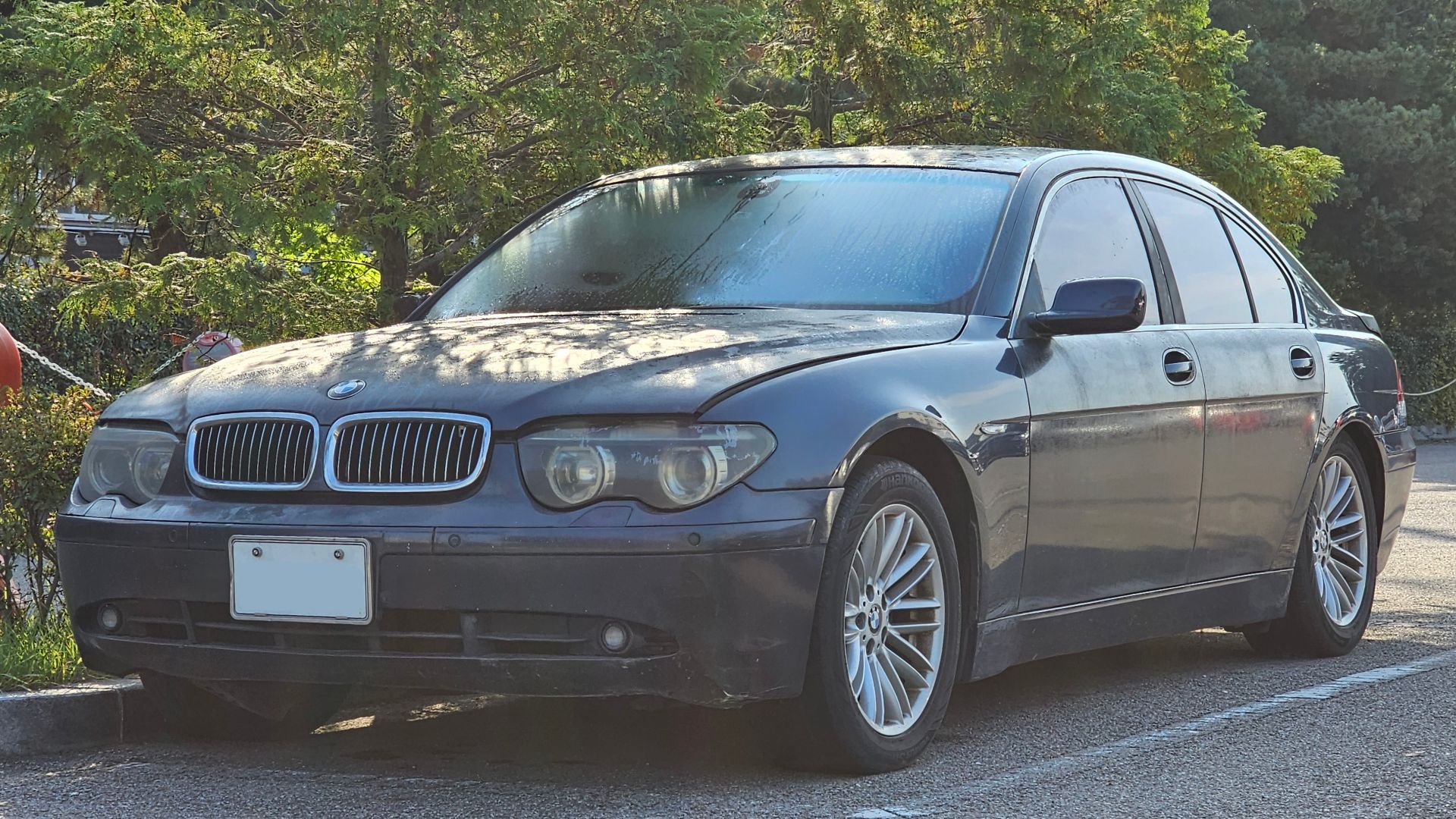 Abandoned Toledo Blue BMW E65 7 Series sedan.