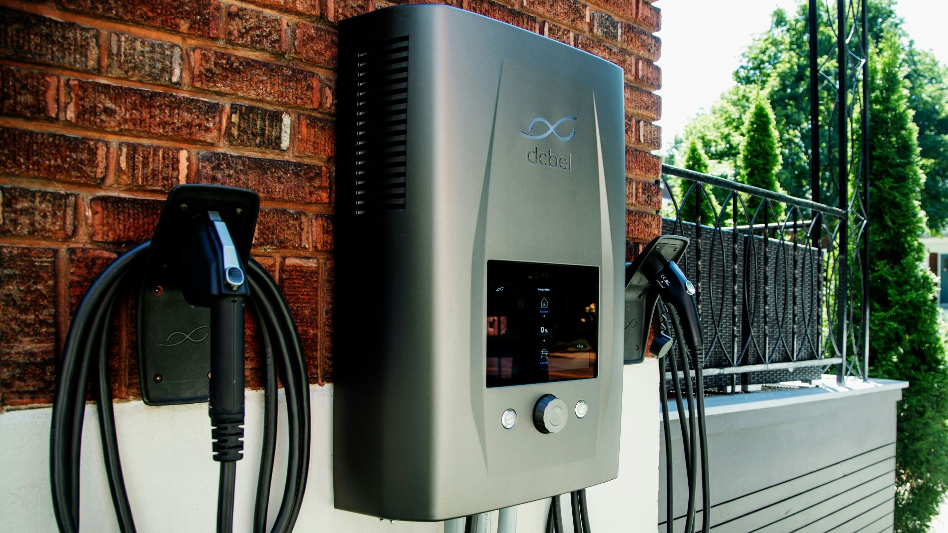 Electric car charging station mounted on brick wall
