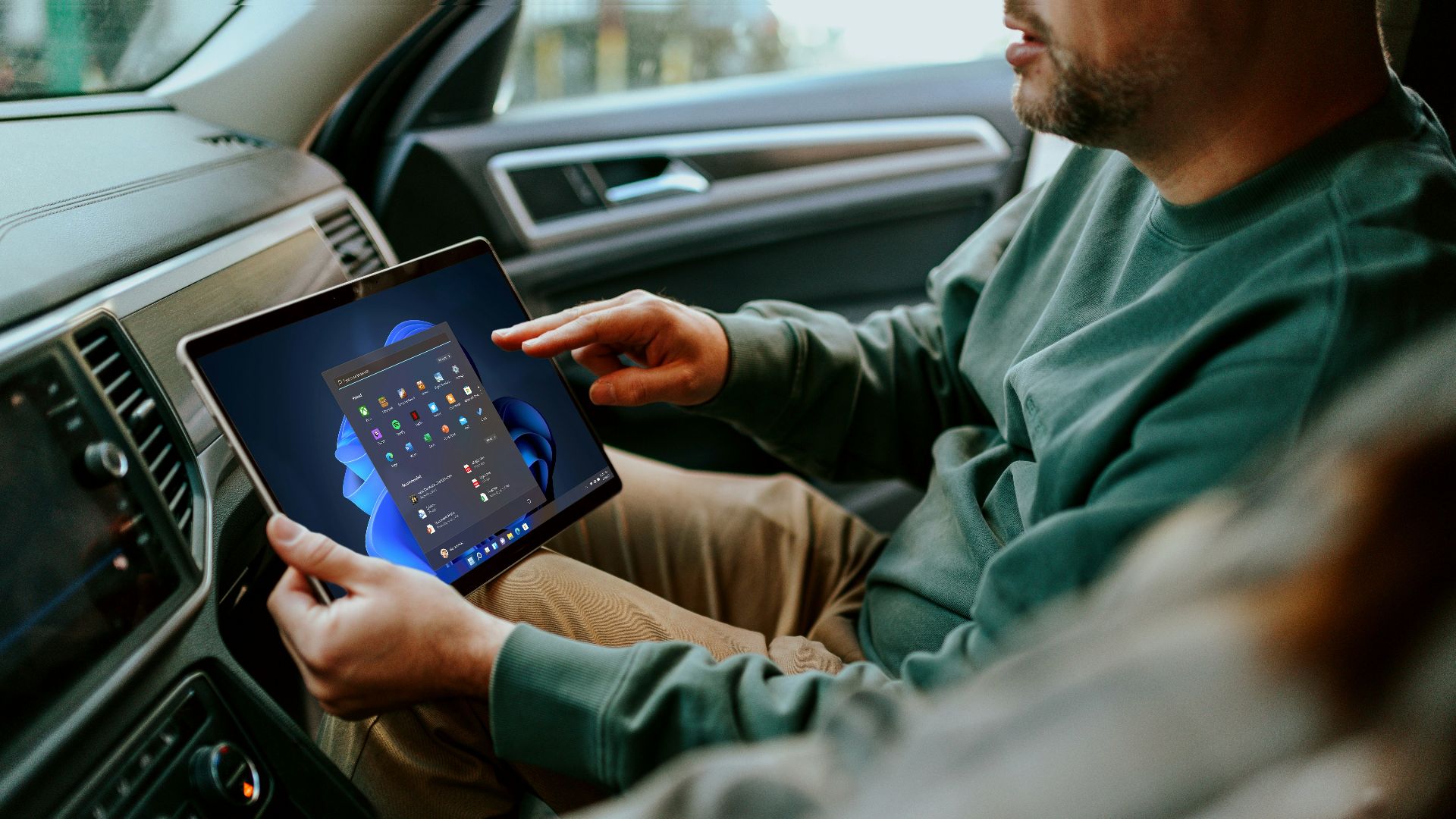 a man sitting in a car holding a tablet