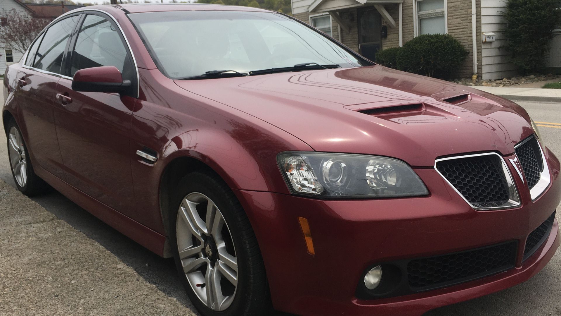A 2009 Pontiac G8 in Sport Red Metallic. This G8 for some reason has an aftermarket Holden logo on the rear. This G8 is a base model, equipped with a 3.6L V6, and made in Elizabeth, South Australia.