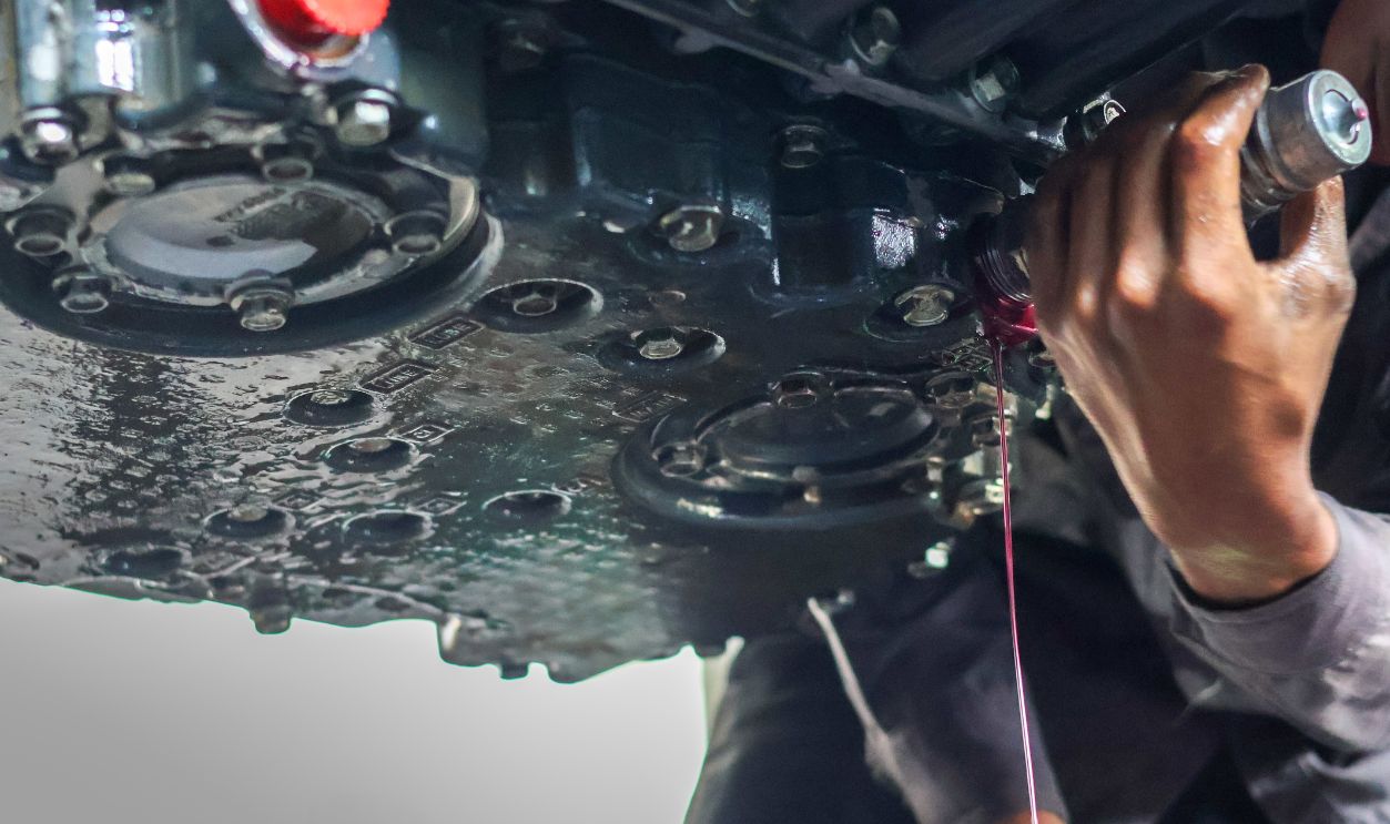 Balikpapan-Indonesia August 8, 2025 Auto mechanic loosen automatic transmission oil drain plug ,then let the old used automatic transmission oil flow out of the transmission oil pan.