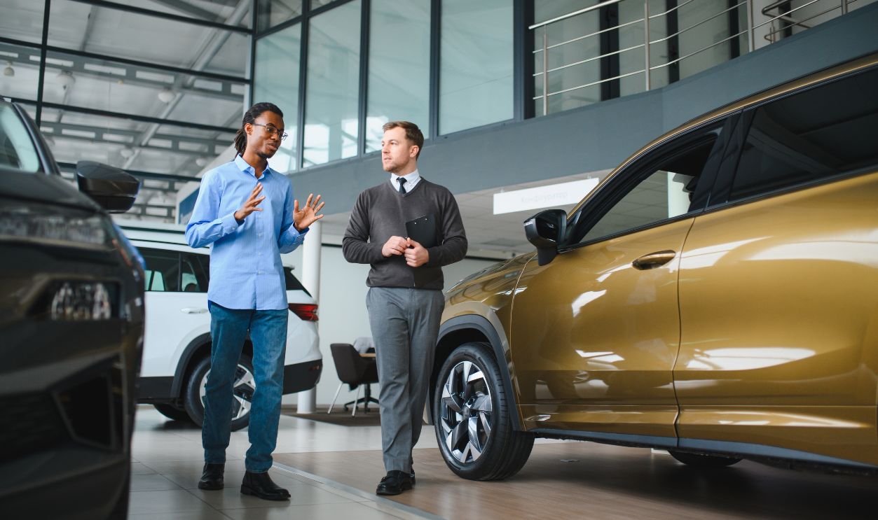 2683893355 - Male car dealer helps customer choose car in car dealership. Man buys new car.