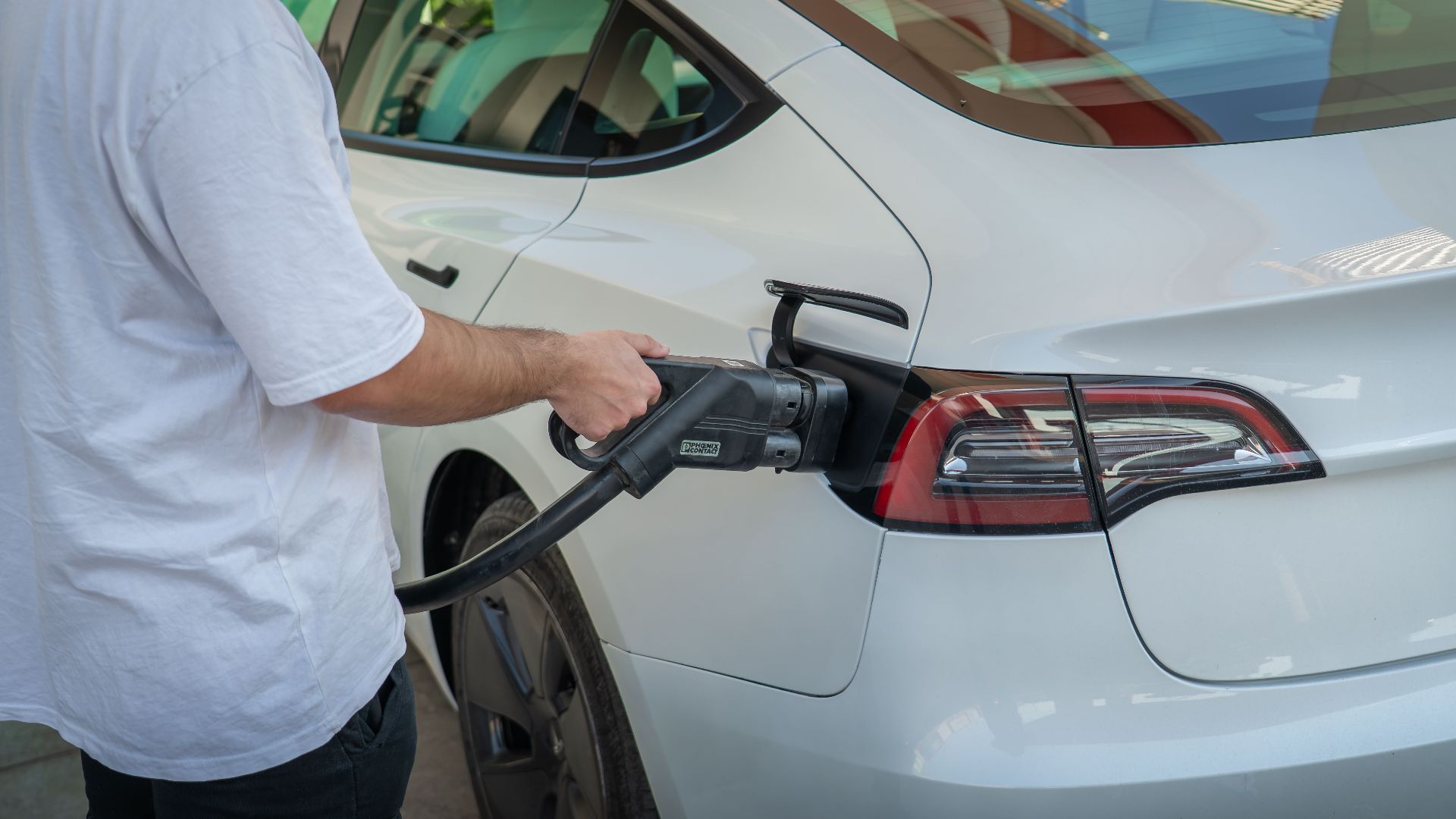 Electric car being charged at a station, highlighting eco-friendly transportation.