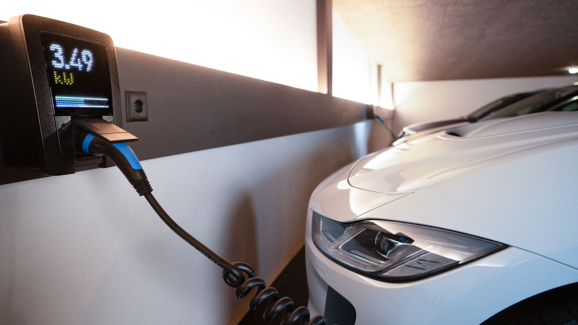 White electric car charging at indoor station, emphasizing sustainability and efficiency.