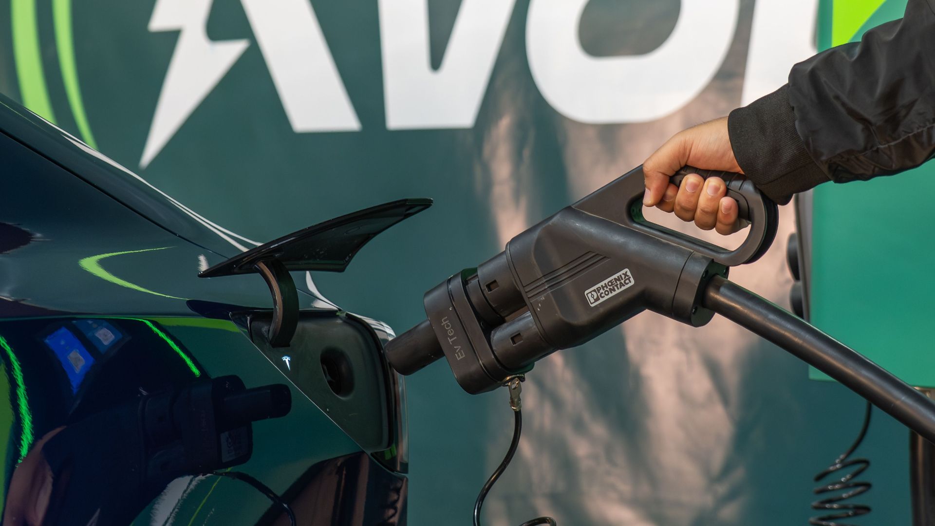 Close-up of an electric car being charged with a visible power plug.