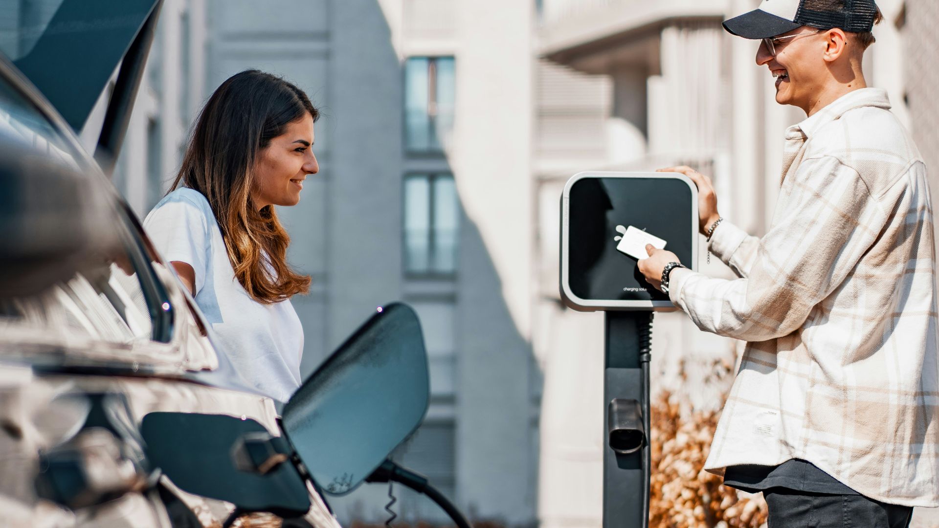 a man and a woman are charging their cars
