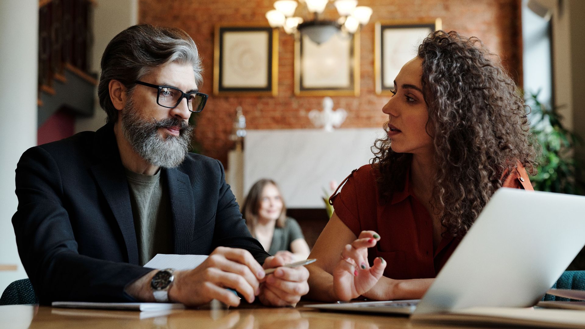 Two business professionals engaging in a strategic discussion with a laptop at a modern office.