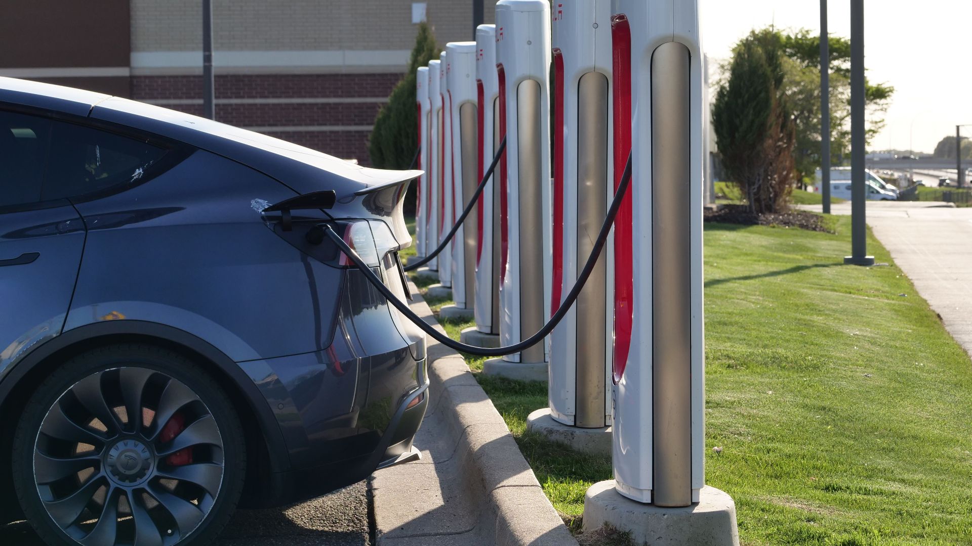 Electric car plugged into a row of charging stations, showcasing modern EV infrastructure.