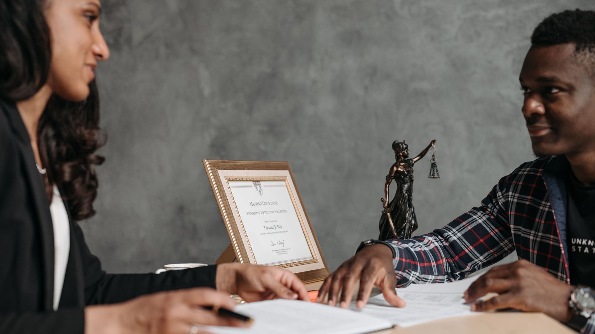 Two professionals engaged in a discussion over legal documents in an office setting.