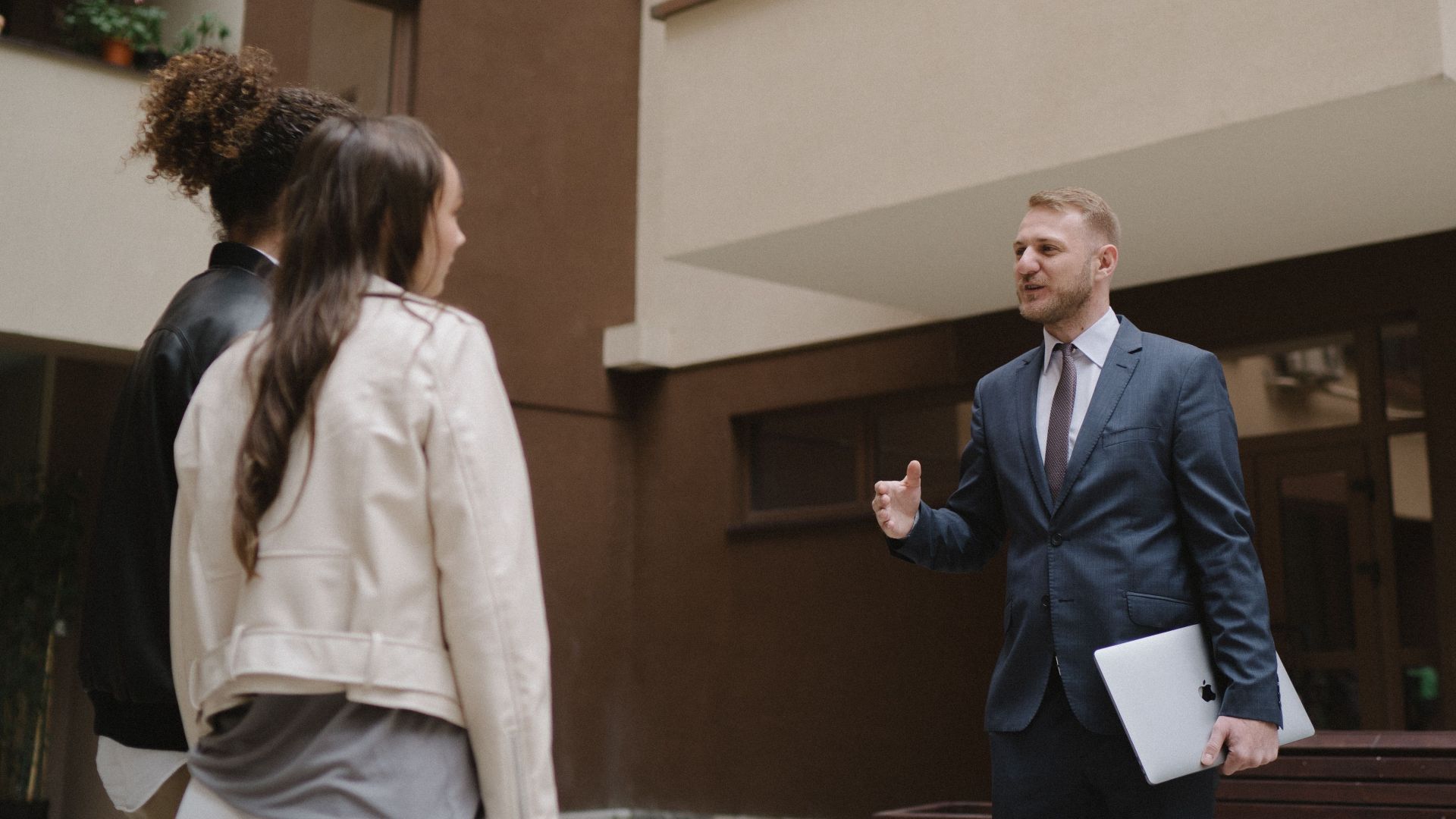 A real estate agent shows an apartment to a couple, illustrating a property tour experience.