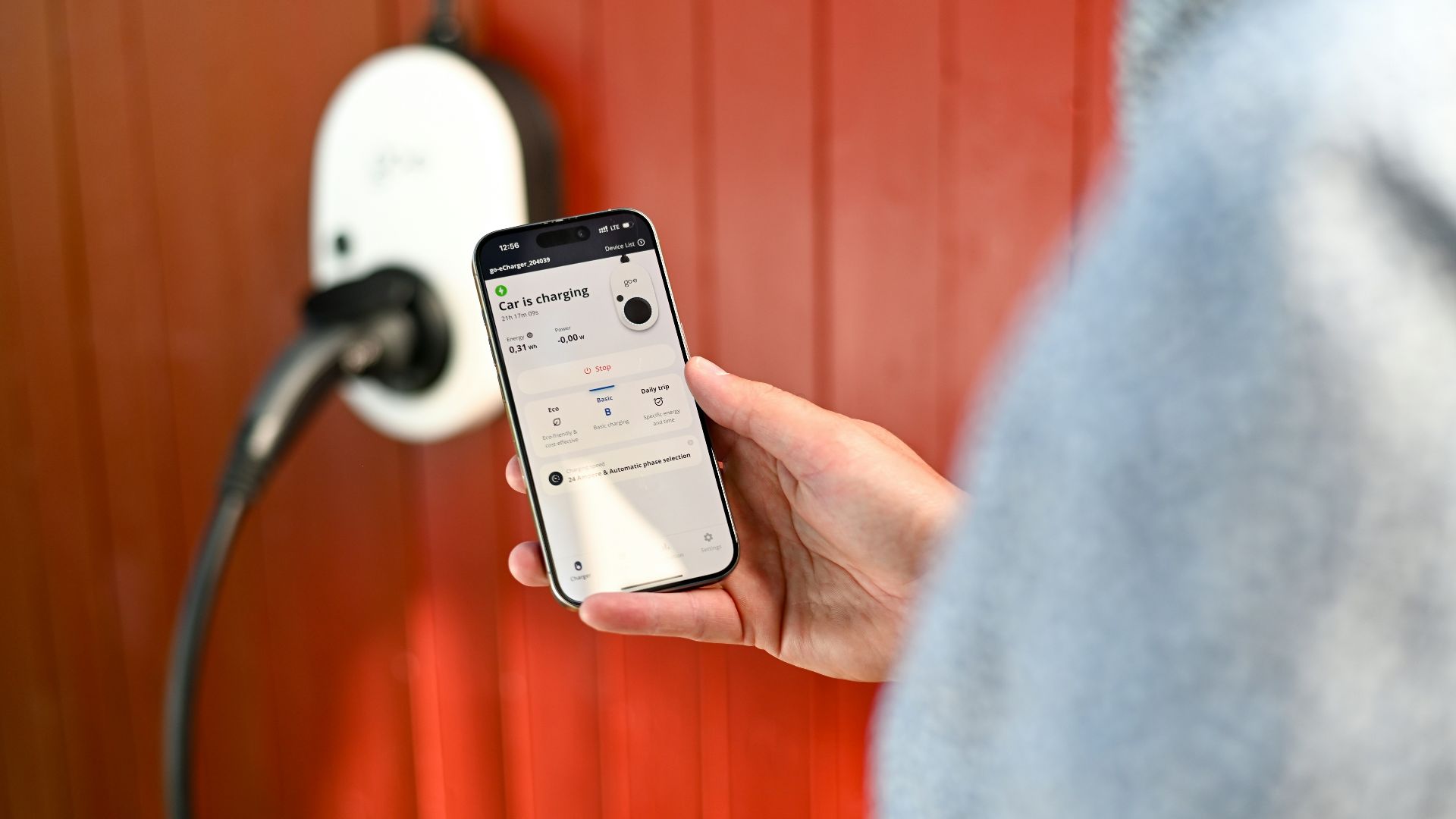 Person uses phone to control electric vehicle charger