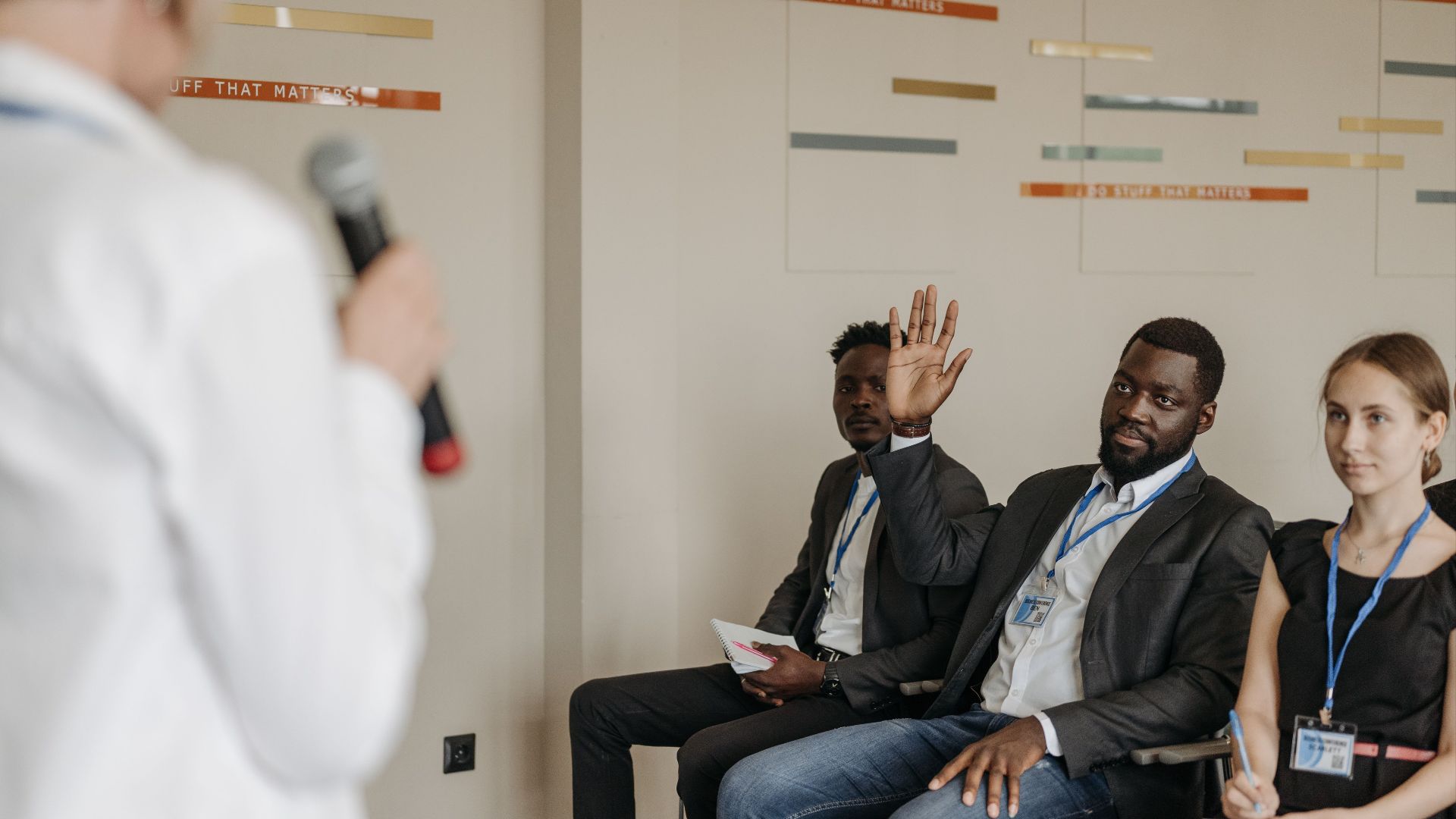 Engaged participants in a business conference, raising questions to the speaker.