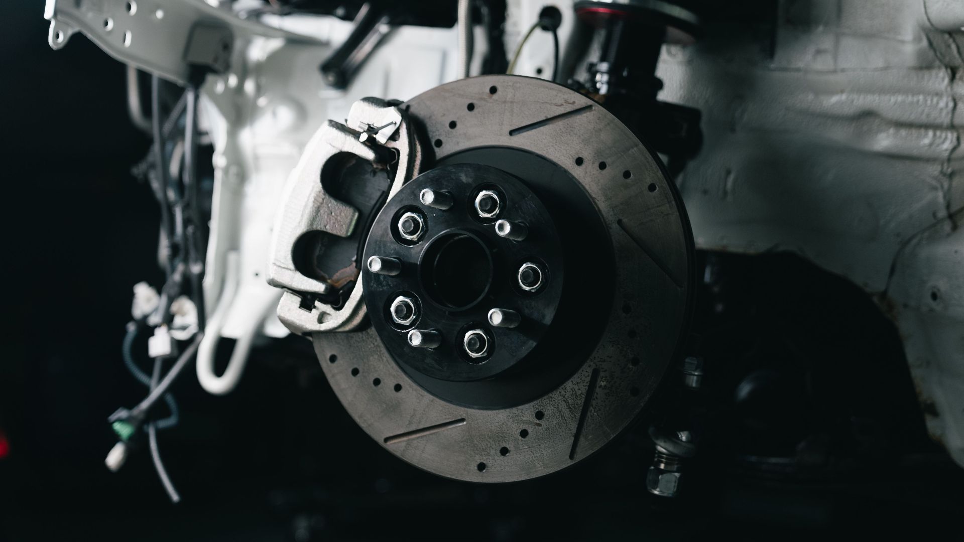 Detailed view of a vehicle's disc brake system with caliper, showcasing automotive technology.