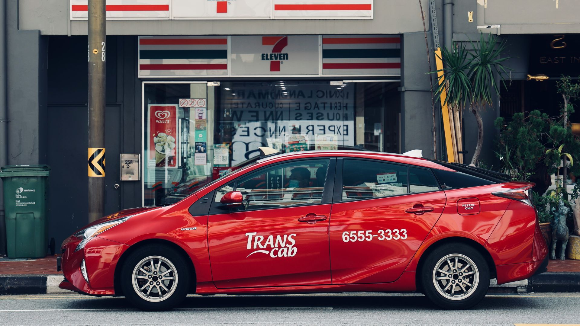 red sedan parked in front of store