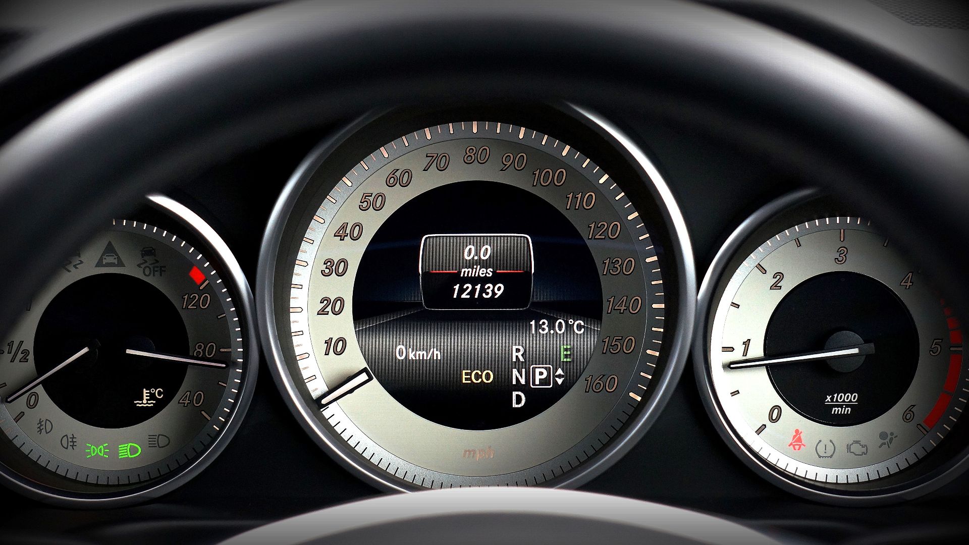 Close-up image of a car dashboard highlighting speedometer, odometer, and temperature gauge.