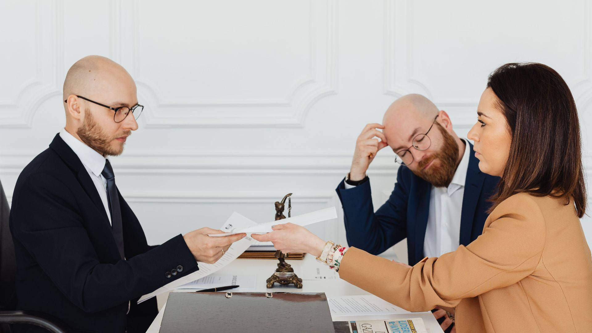 Professional meeting with lawyer and clients discussing documents in a modern office.
